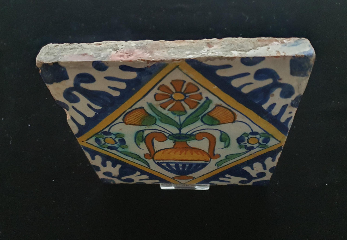 Een polychrome Nederlandse majolicategel met de decoratie van een kleurrijke bloemenvaas; Dutch 17e eeuw, verzameltegel, backsplash