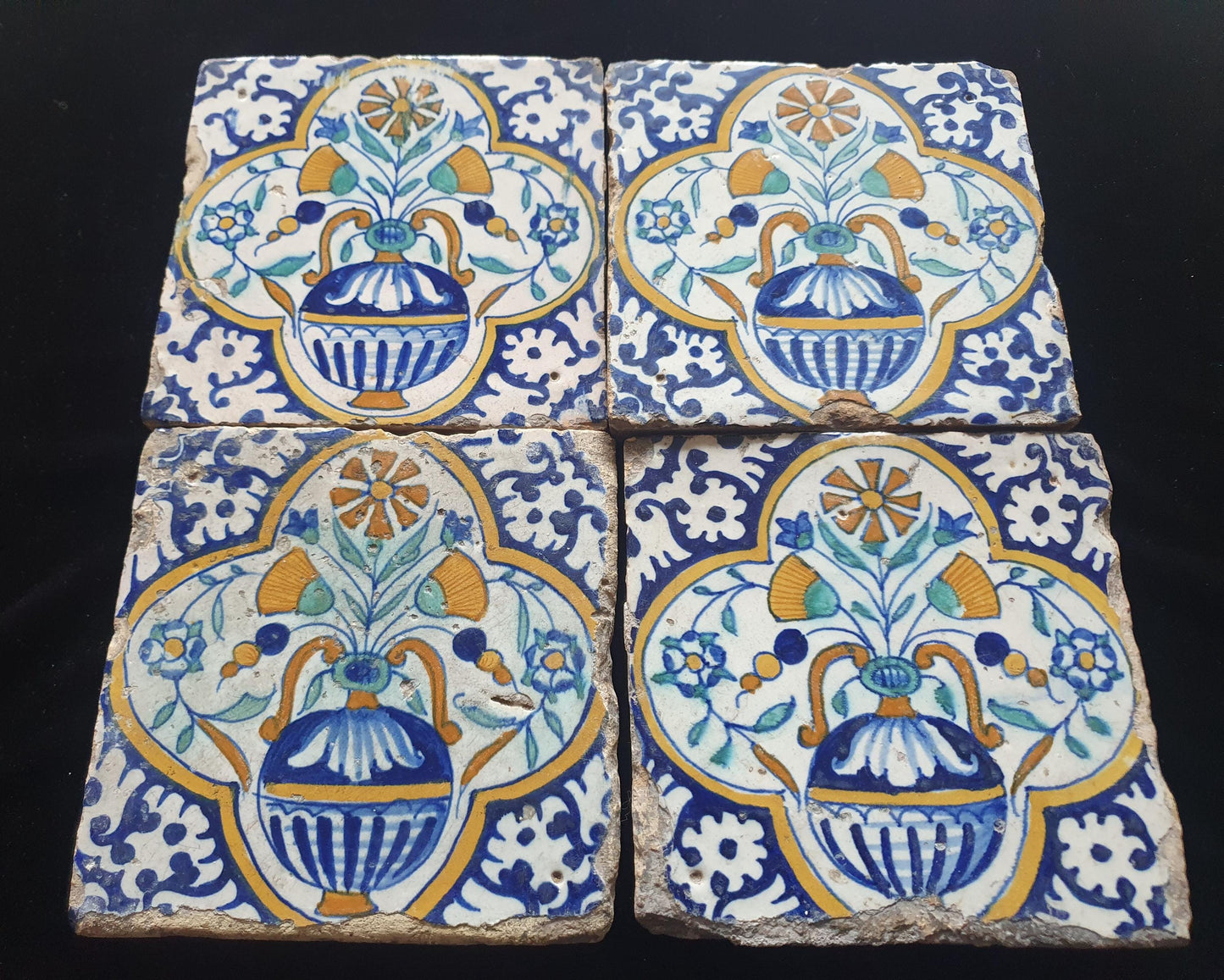Een set van 4 polychrome Nederlandse majolicategels met de decoratie van een kleurrijke bloemenvaas; Dutch 17e eeuw, verzameltegels.