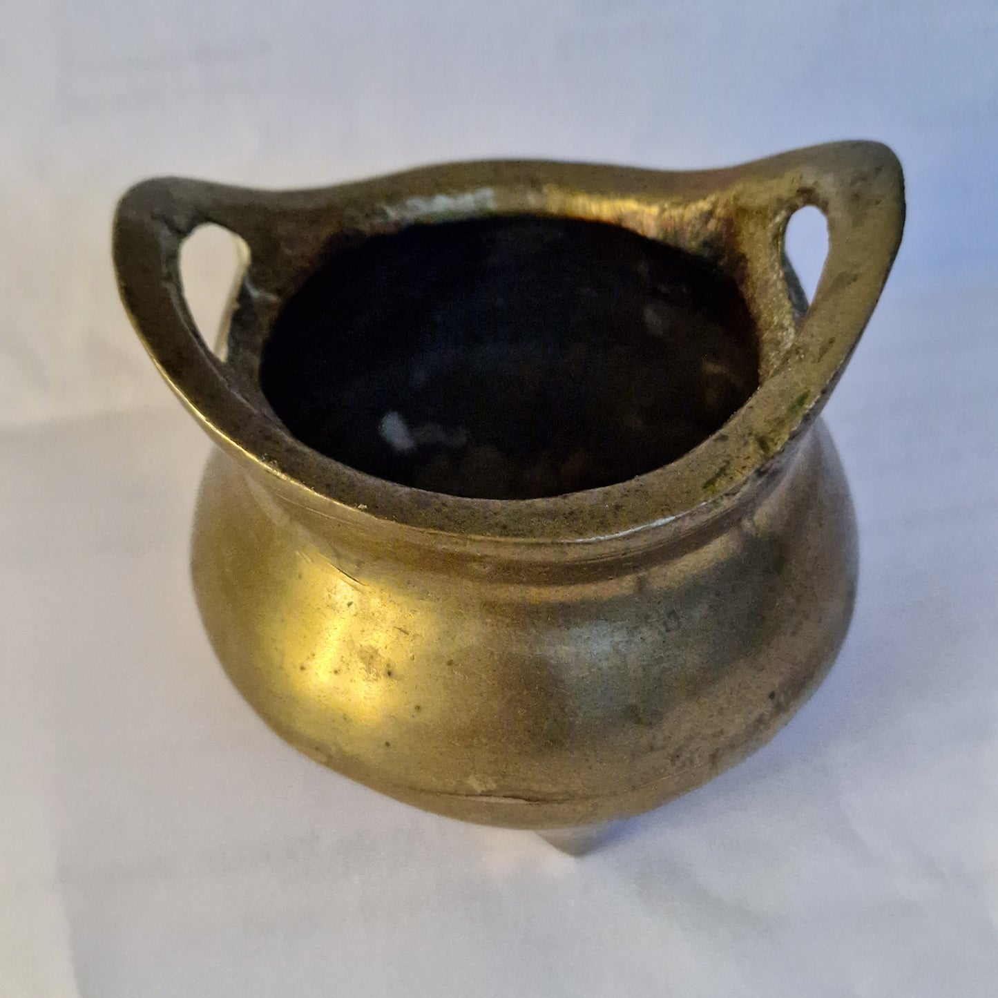 A Chinese bronze tripod censer, of typical shallow rounded form, supported on three short legs, the base with an apocryphal character mark