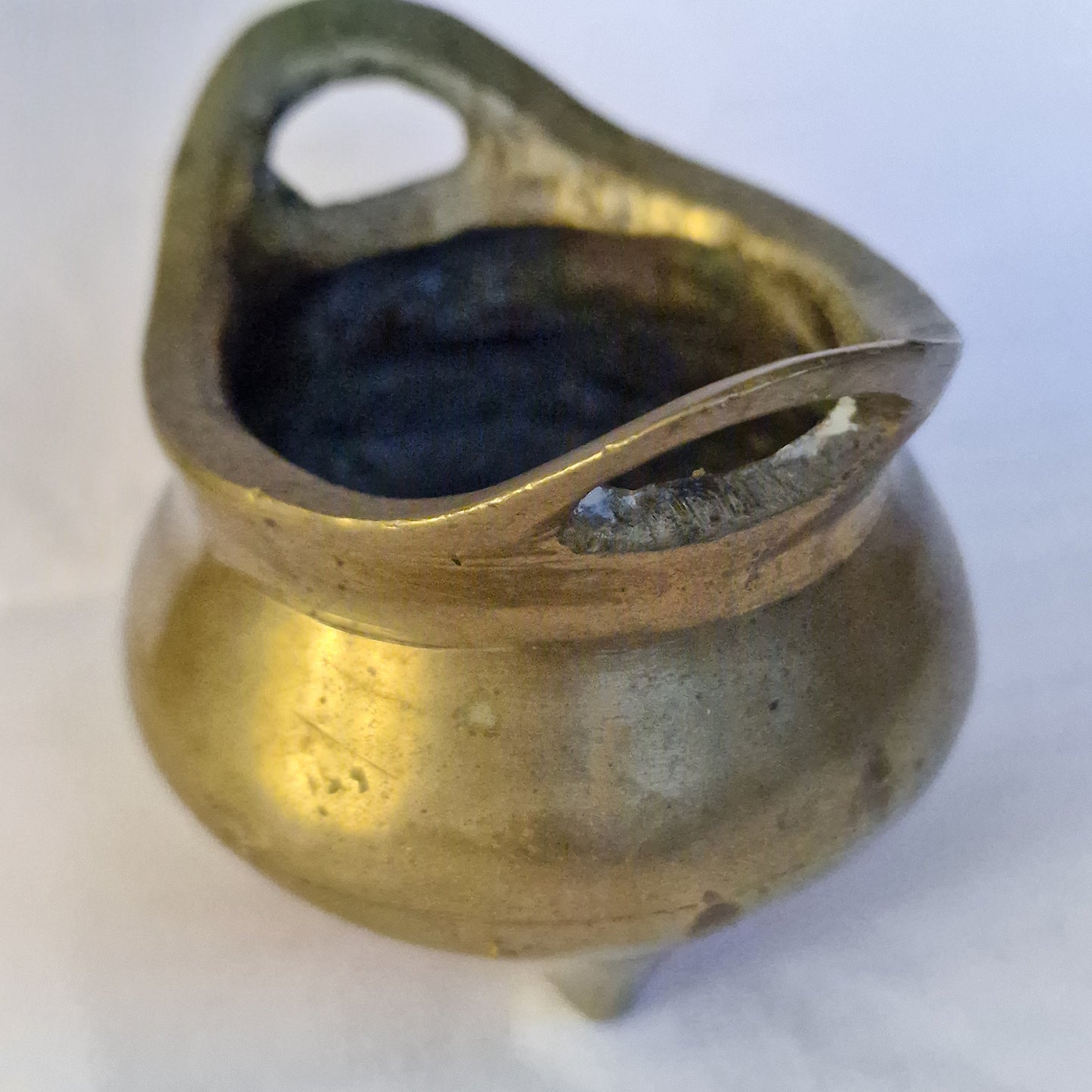 A Chinese bronze tripod censer, of typical shallow rounded form, supported on three short legs, the base with an apocryphal character mark