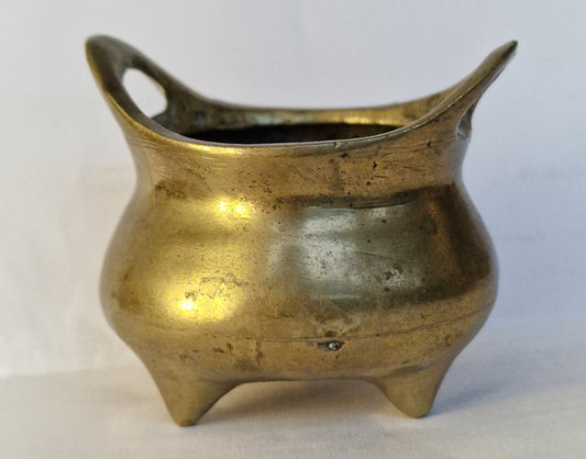 A Chinese bronze tripod censer, of typical shallow rounded form, supported on three short legs, the base with an apocryphal character mark