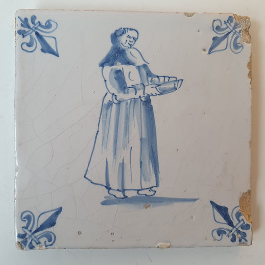 Nederlands antiek - tegel marktkoopvrouw , gedecoreerd met een lelie hoekmotief - gedateerd  1640