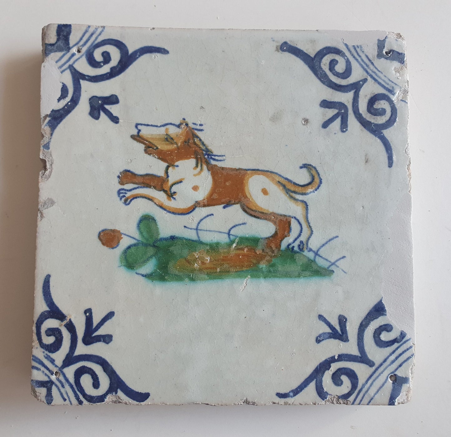 Antique Delft Tile – 17th Century Dog, Oxhead Corner Motif