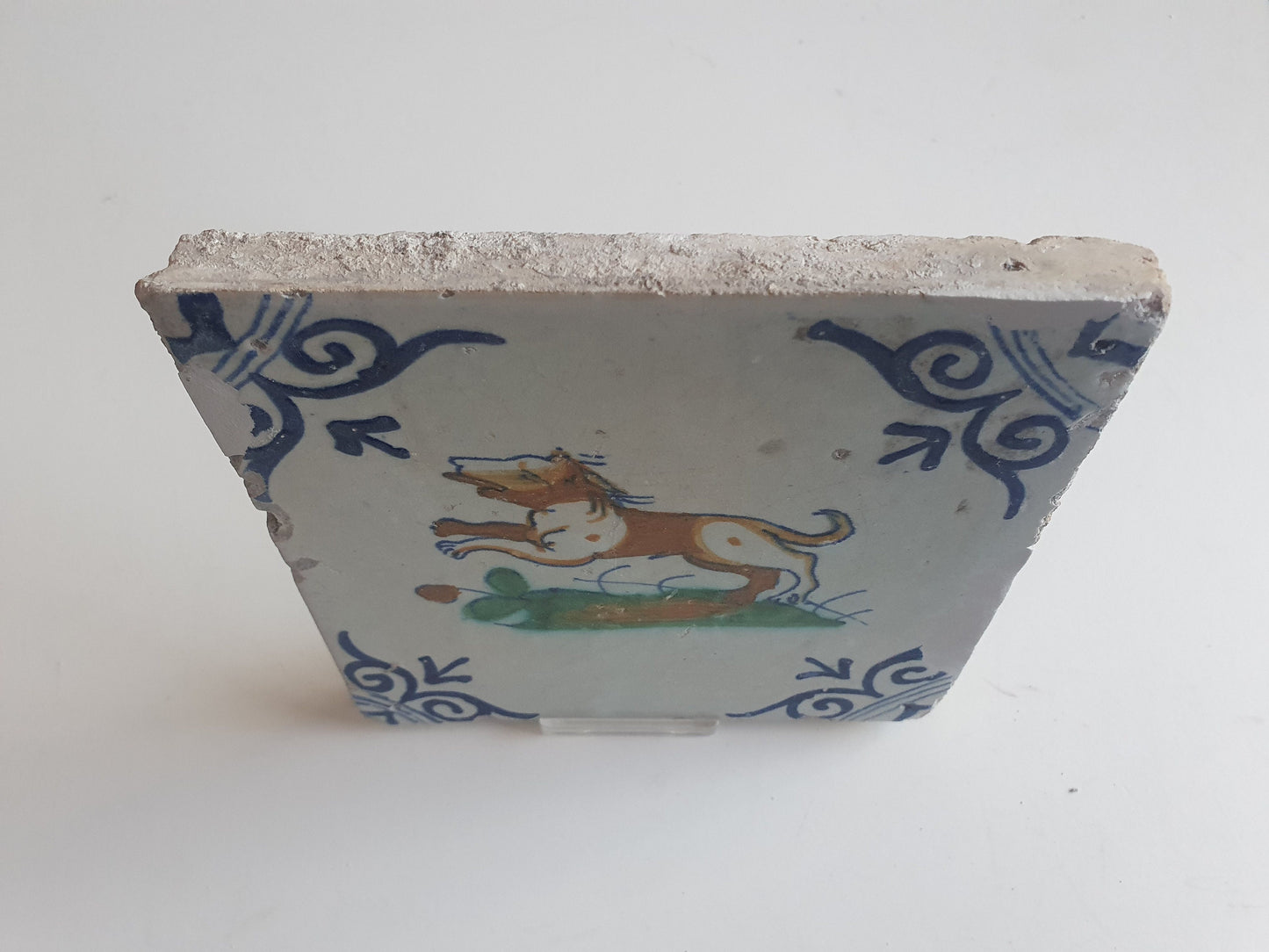 Antique Delft Tile – 17th Century Dog, Oxhead Corner Motif