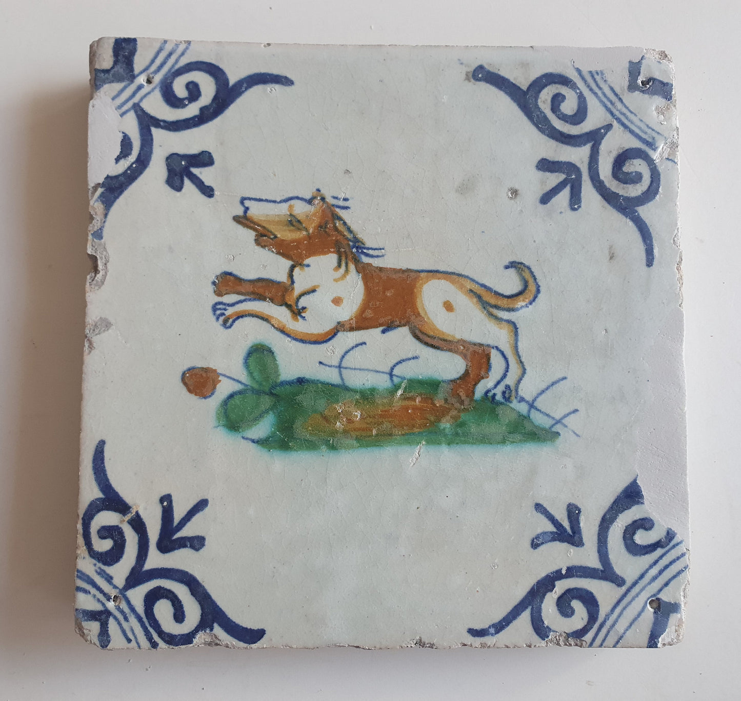 Antique Delft Tile – 17th Century Dog, Oxhead Corner Motif