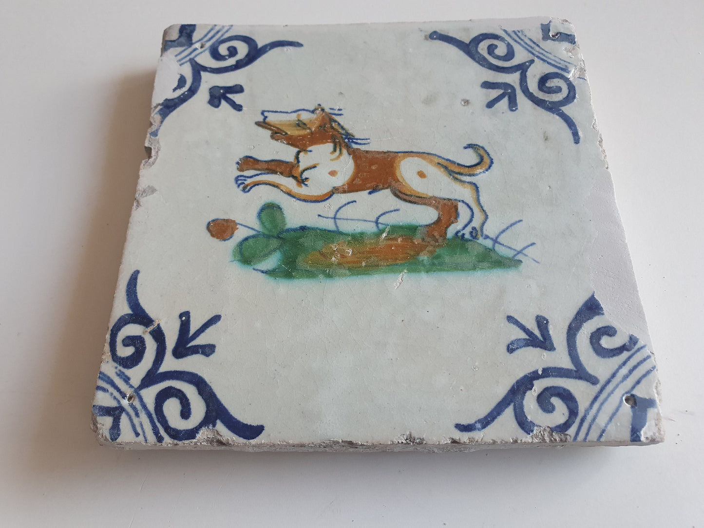 Antique Delft Tile – 17th Century Dog, Oxhead Corner Motif