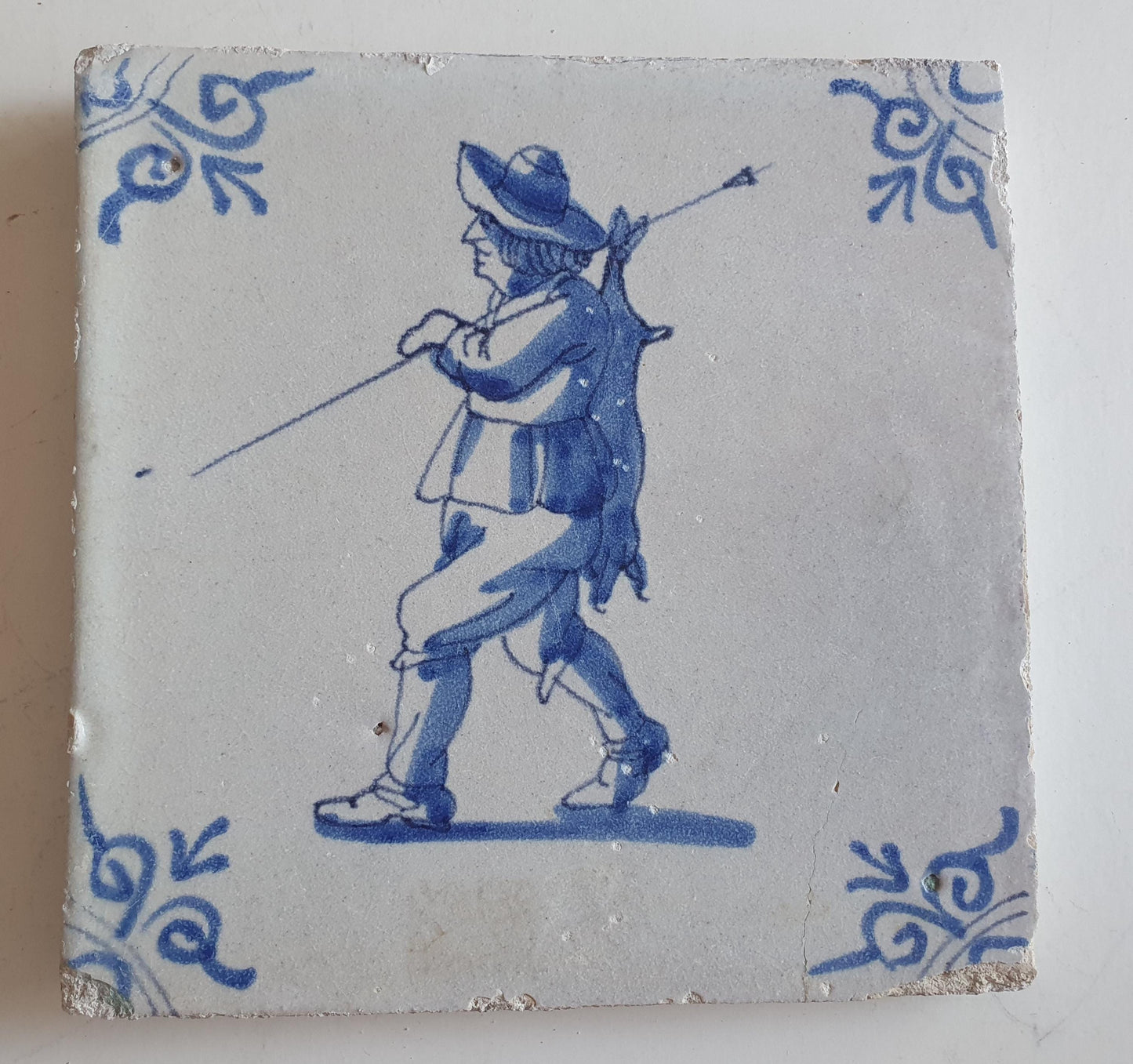 Dutch antique tile, 17th century, hunter with hare on his back, oxhead corner Rare !