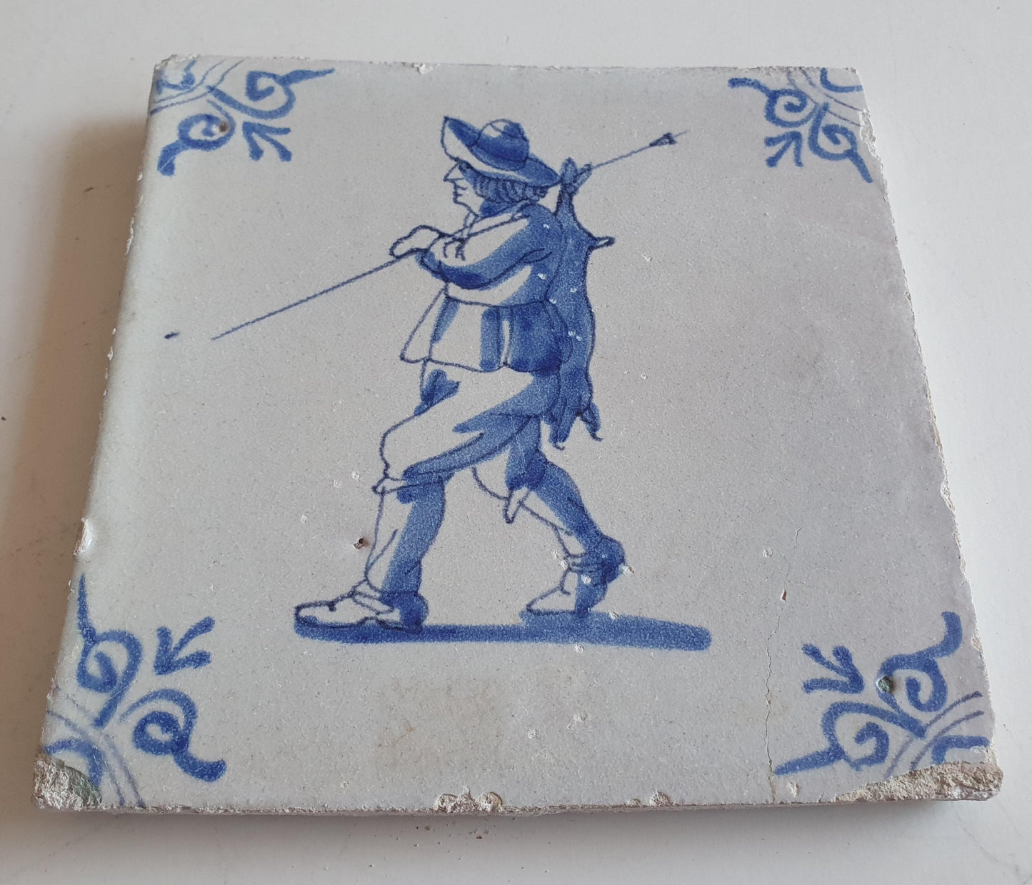 Dutch antique tile, 17th century, hunter with hare on his back, oxhead corner Rare !
