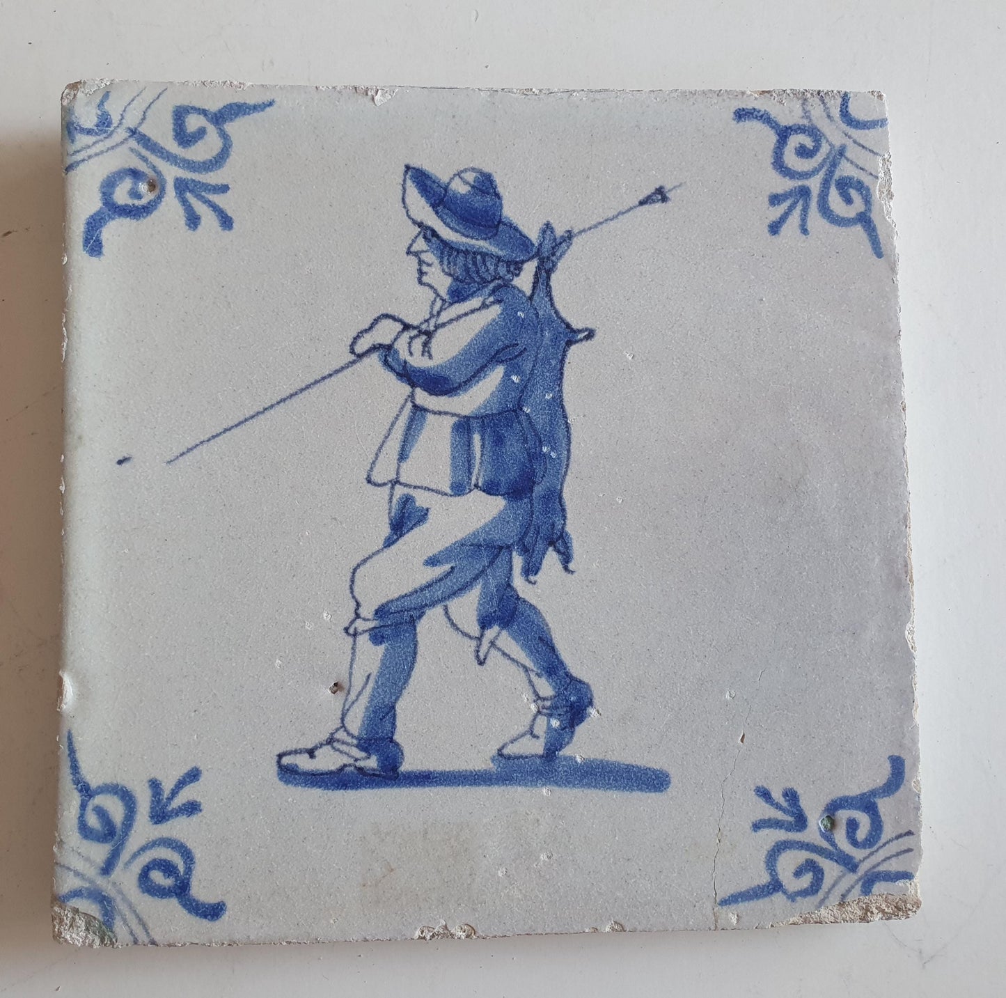 Dutch antique tile, 17th century, hunter with hare on his back, oxhead corner Rare !