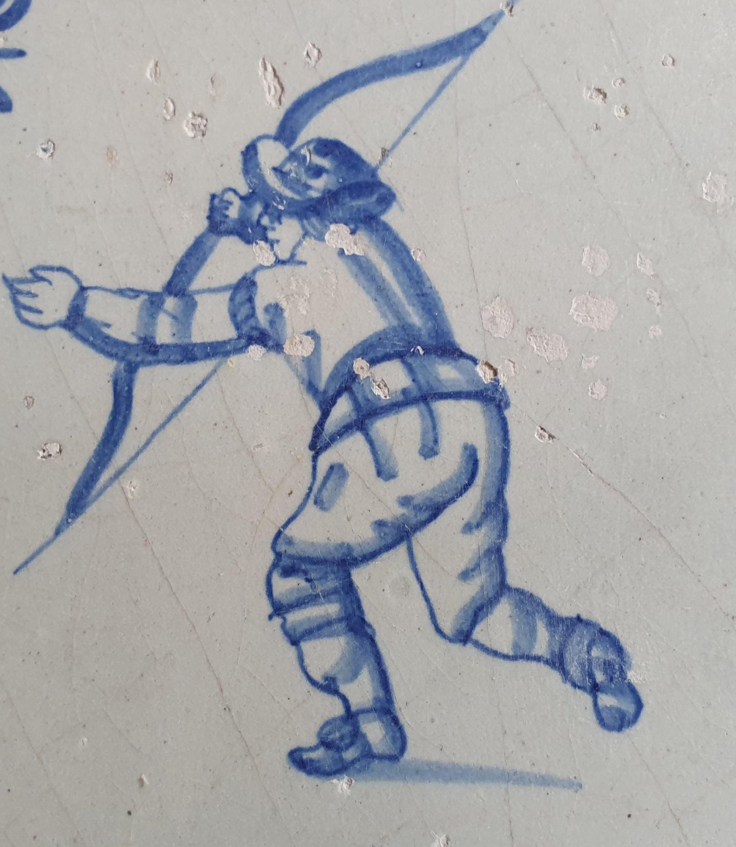 17th Delft tile was  made around 1650 and depicts a  child with a bow and arrow.