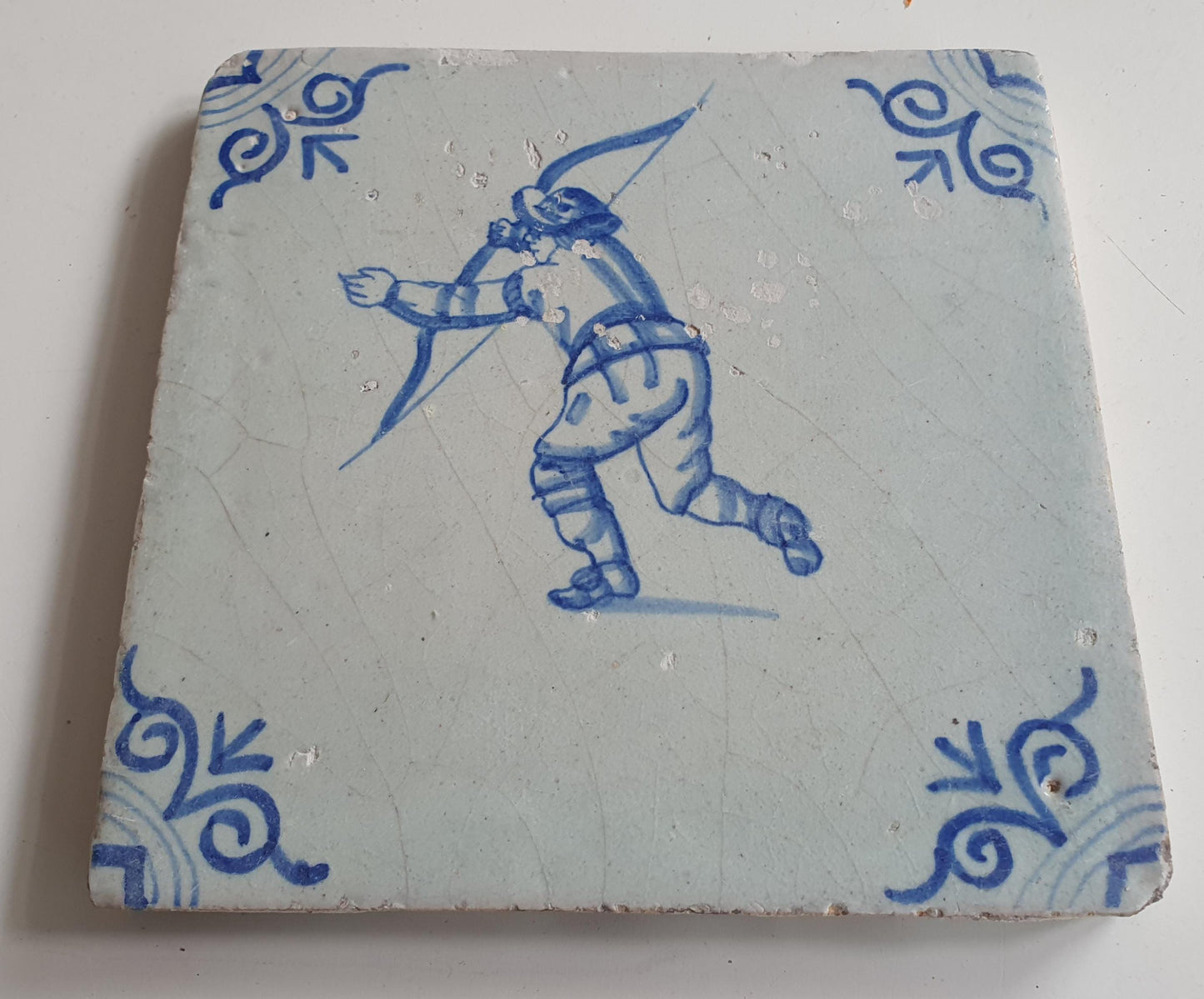 17th Delft tile was  made around 1650 and depicts a  child with a bow and arrow.