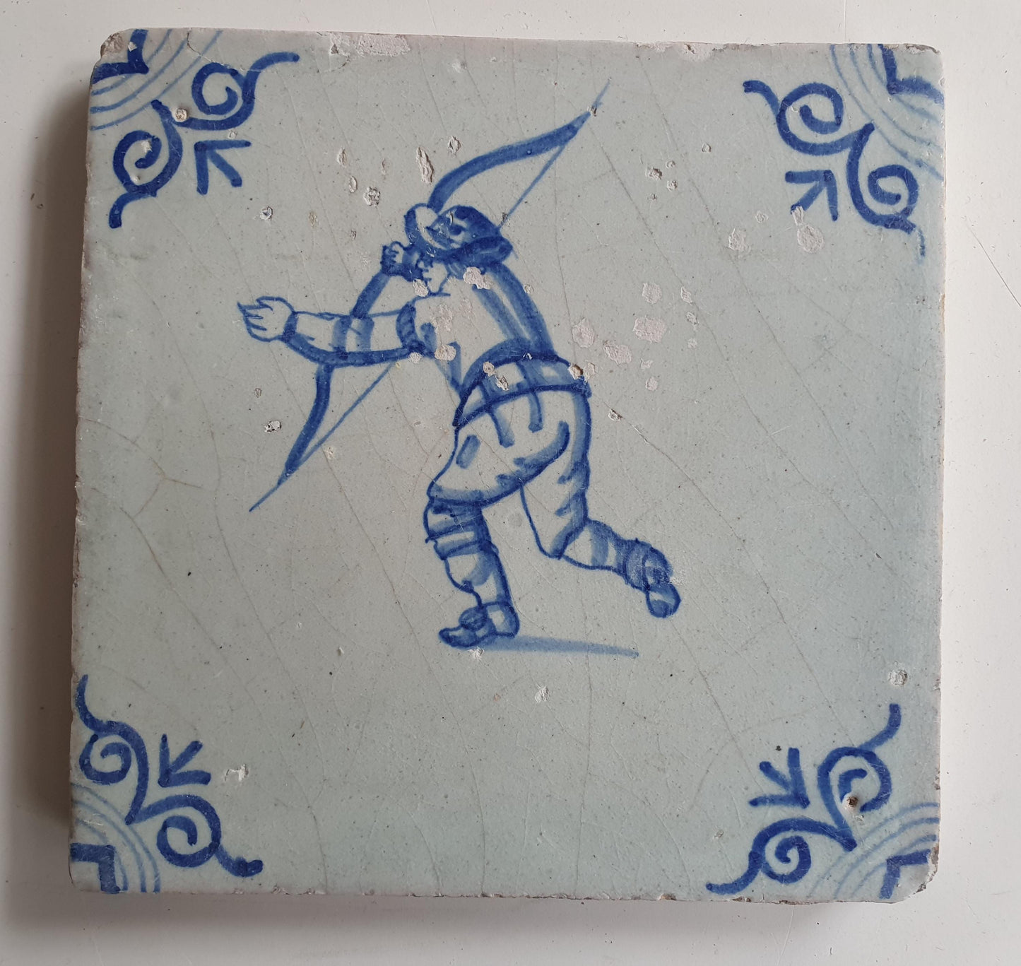 17th Delft tile was  made around 1650 and depicts a  child with a bow and arrow.