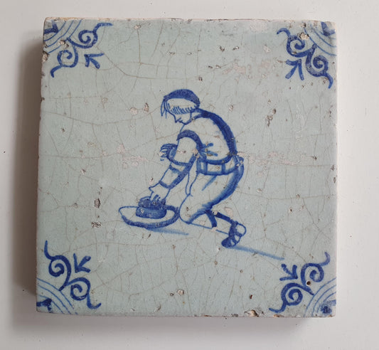 17th Delft tile was  made around 1650 and depicts a  child with a hat