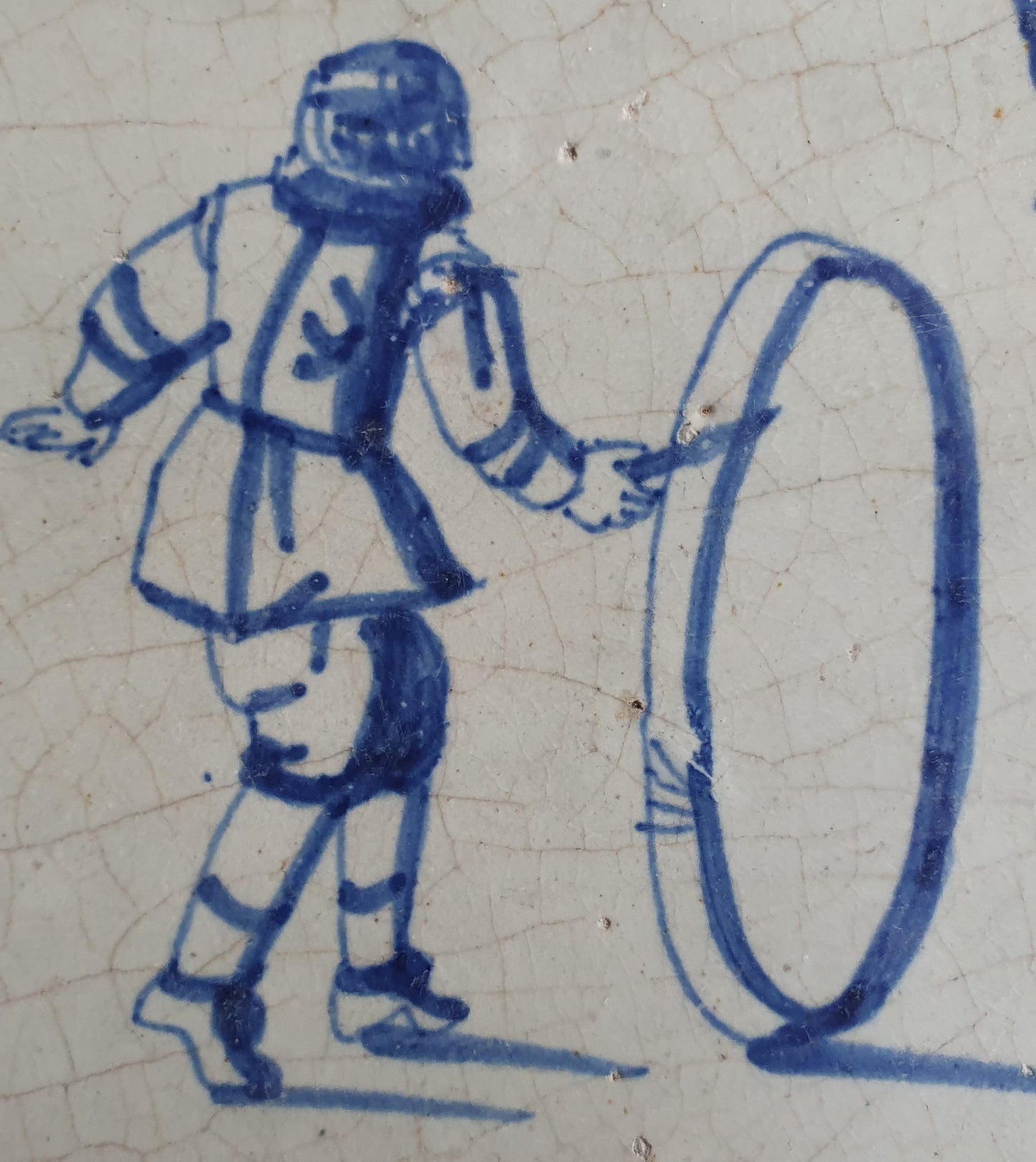 17th Delft tile was  made around 1650 and depicts a  child with a  hoop