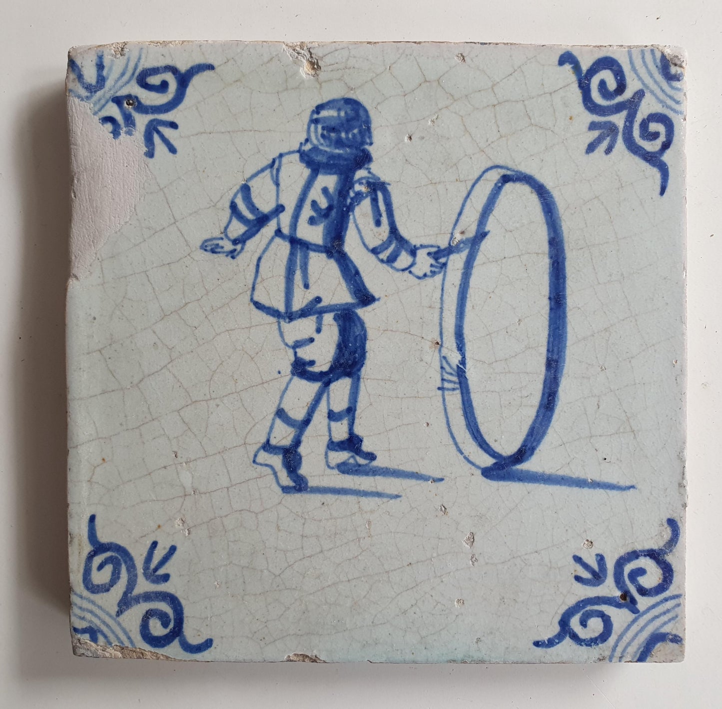 17th Delft tile was  made around 1650 and depicts a  child with a  hoop
