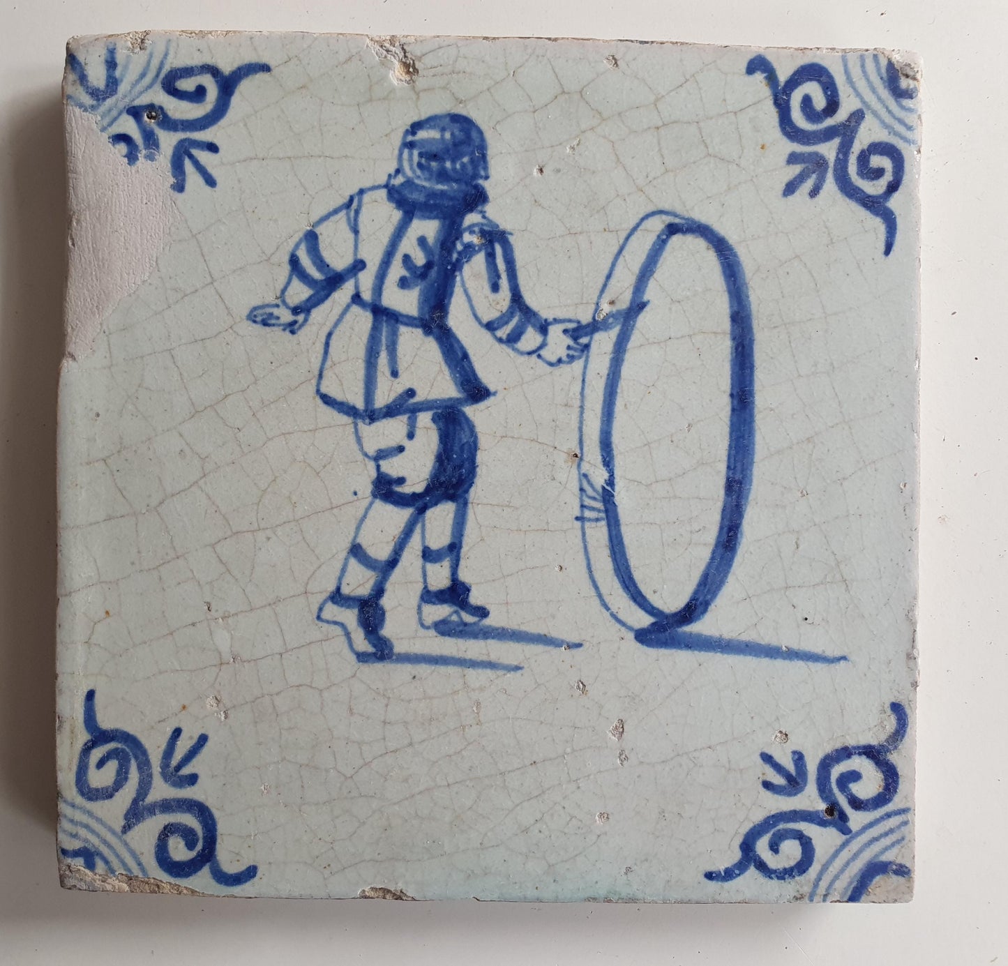 17th Delft tile was  made around 1650 and depicts a  child with a  hoop