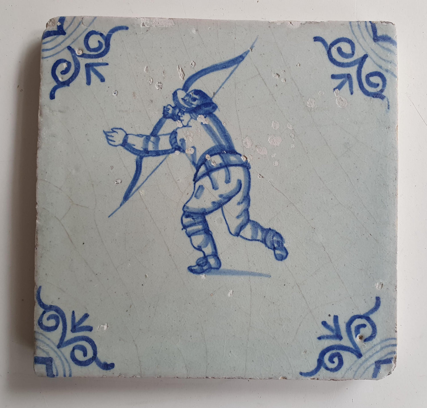 17th Delft tile was  made around 1650 and depicts a  child with a bow and arrow.
