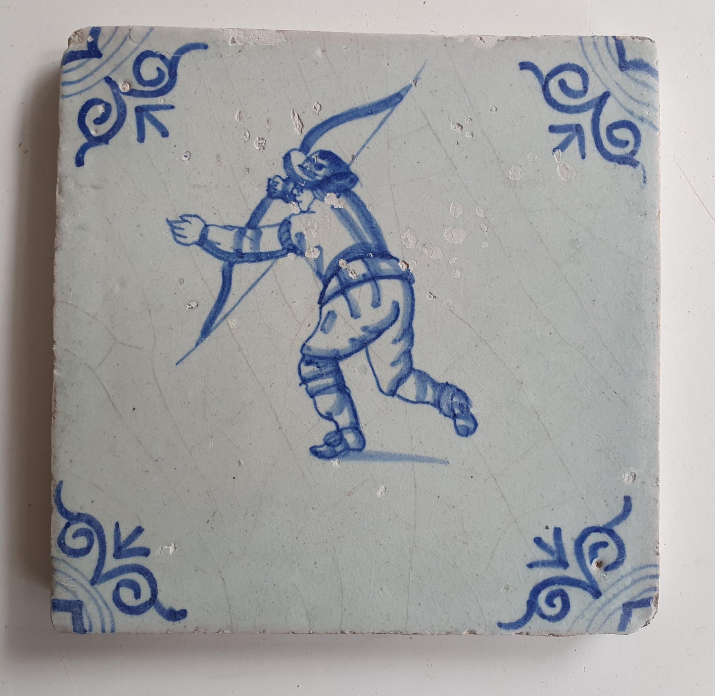 17th Delft tile was  made around 1650 and depicts a  child with a bow and arrow.