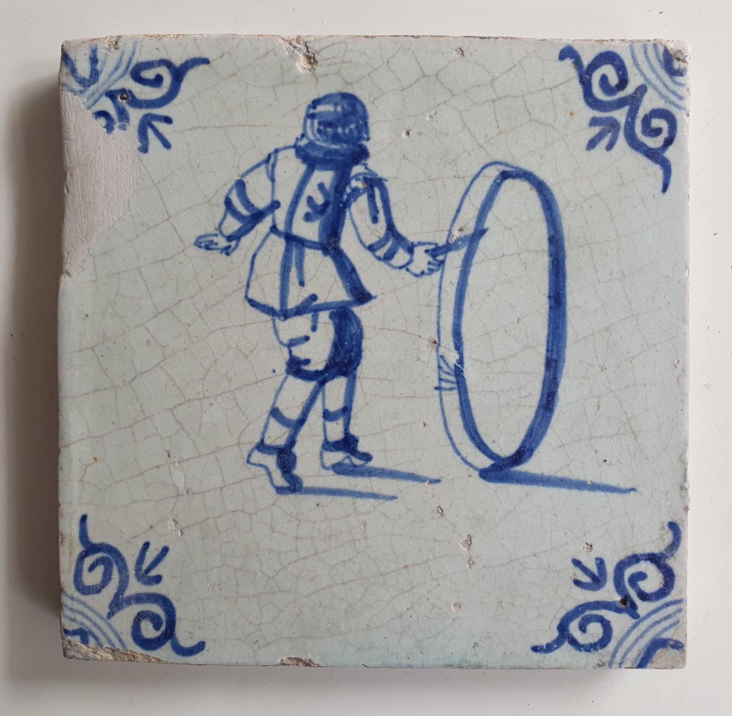 17th Delft tile was  made around 1650 and depicts a  child with a  hoop