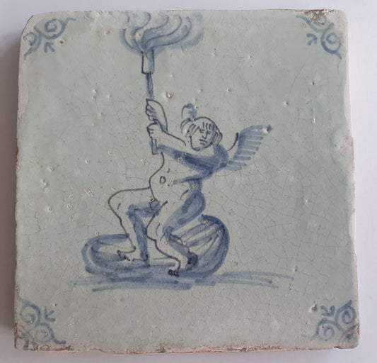 This antique Delft tile depicts Cupid lifting a burning torch in the sky. 17th century