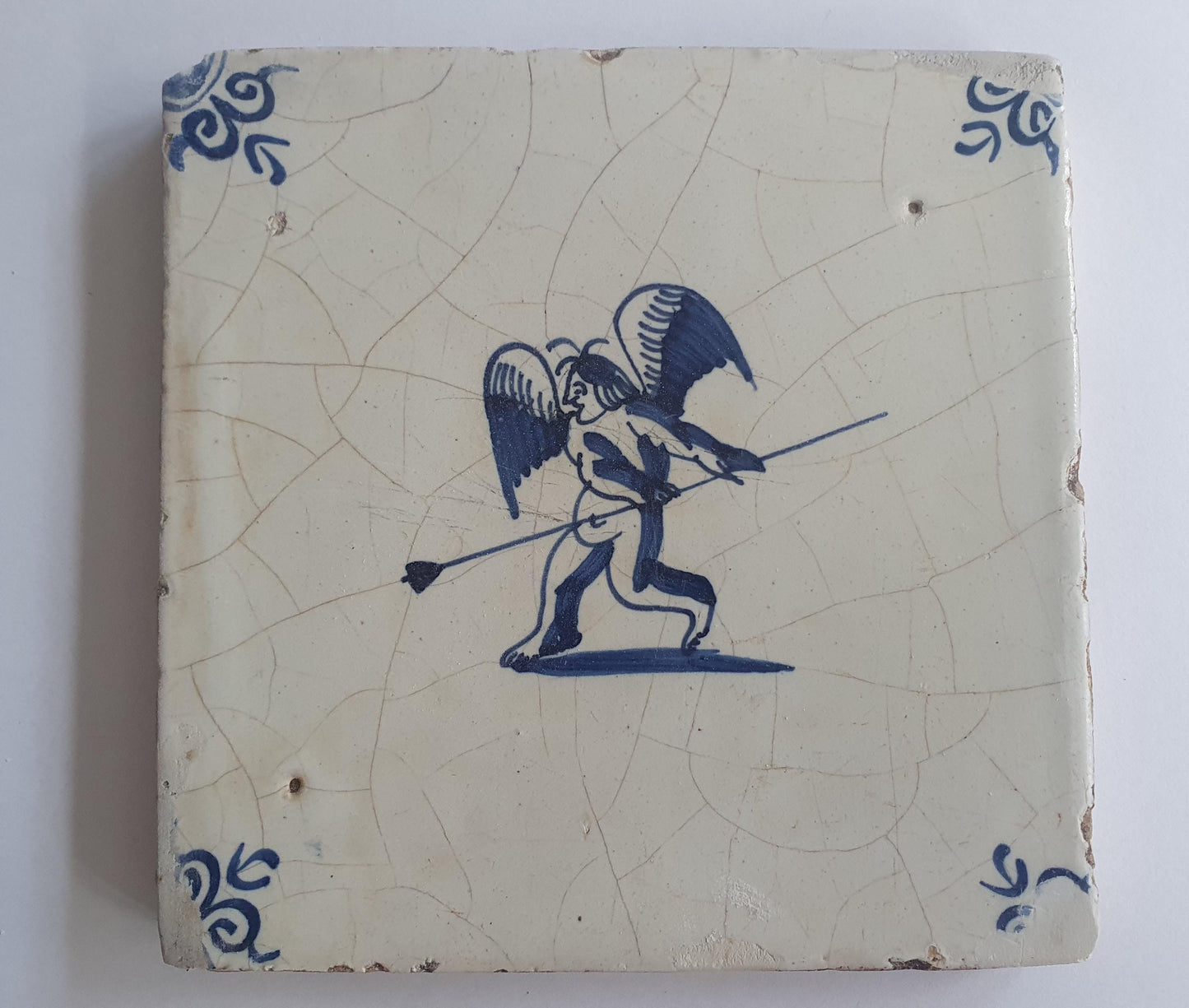 This antique Delft tile, dating from around 1640, depicts Cupid with stick.