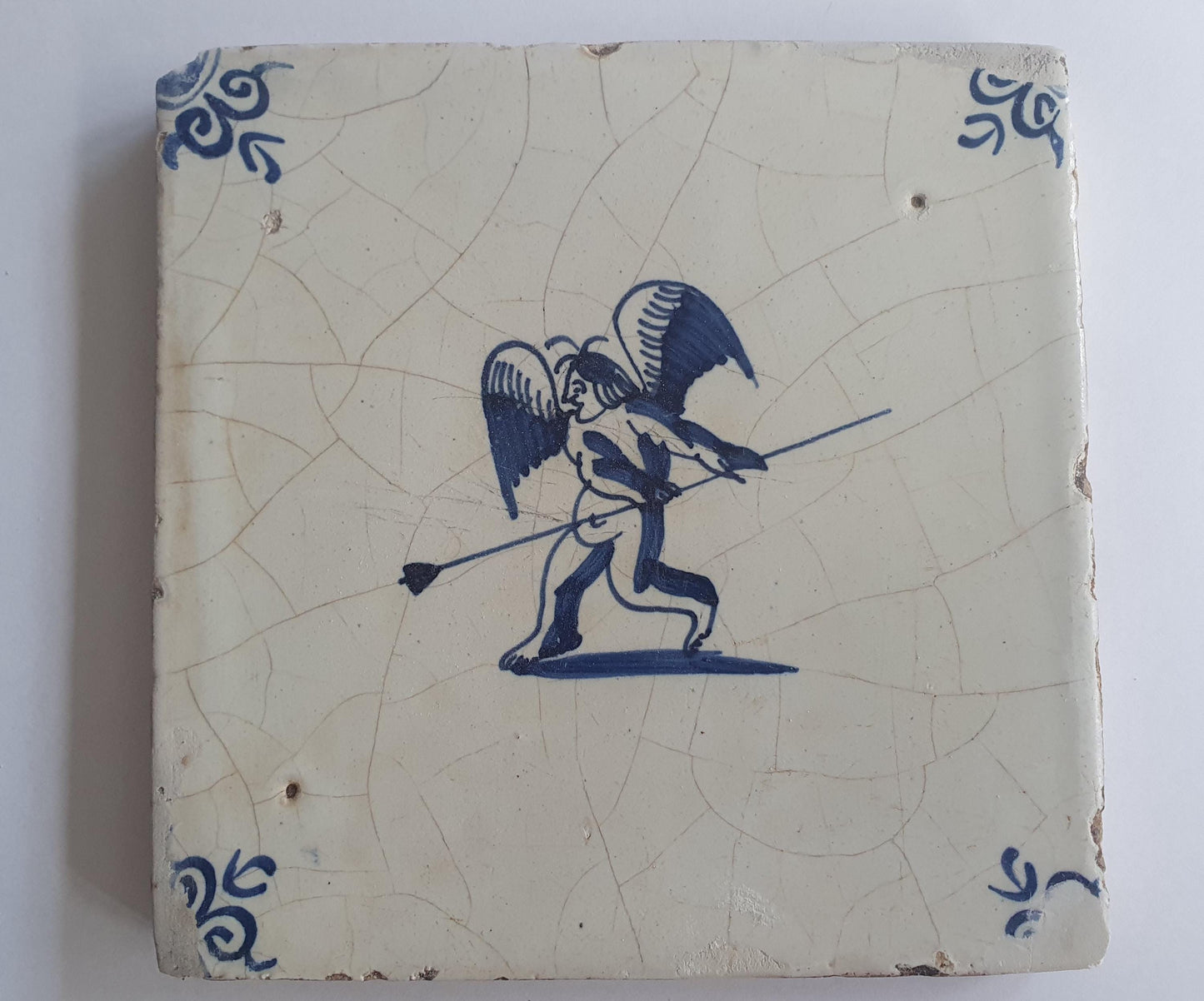 This antique Delft tile, dating from around 1640, depicts Cupid with stick.