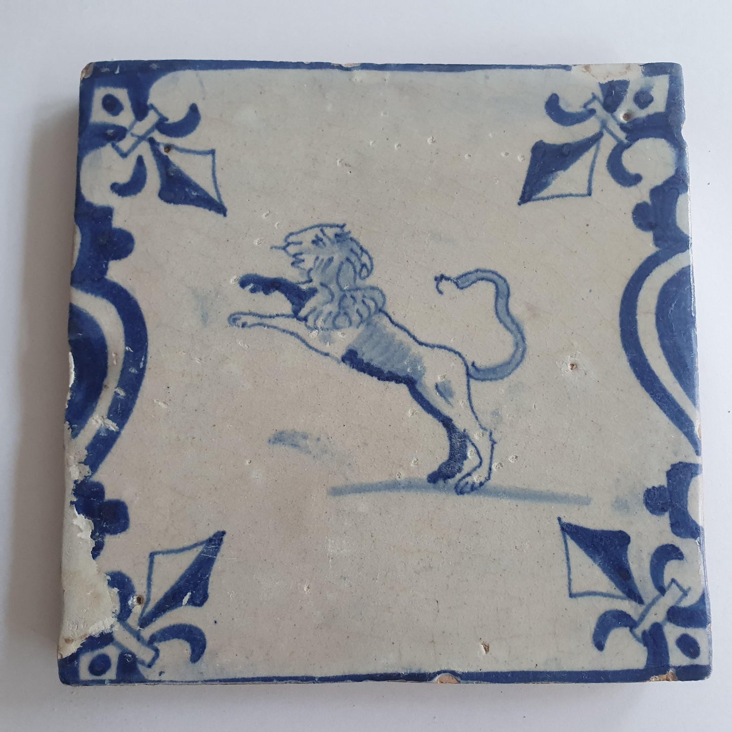 This 17th century Delft tile depicts a leaping lion, delicately painted in blue