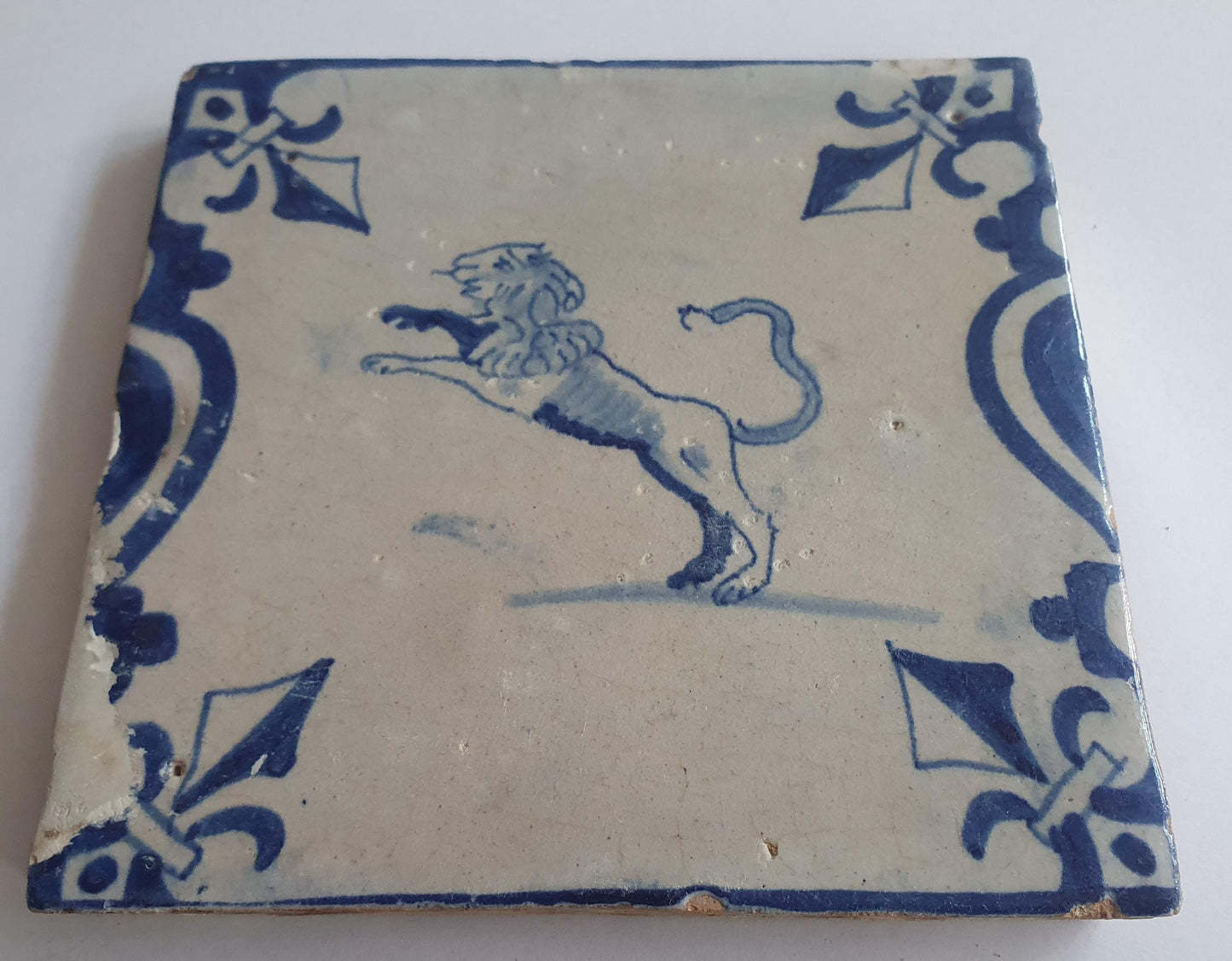 This 17th century Delft tile depicts a leaping lion, delicately painted in blue