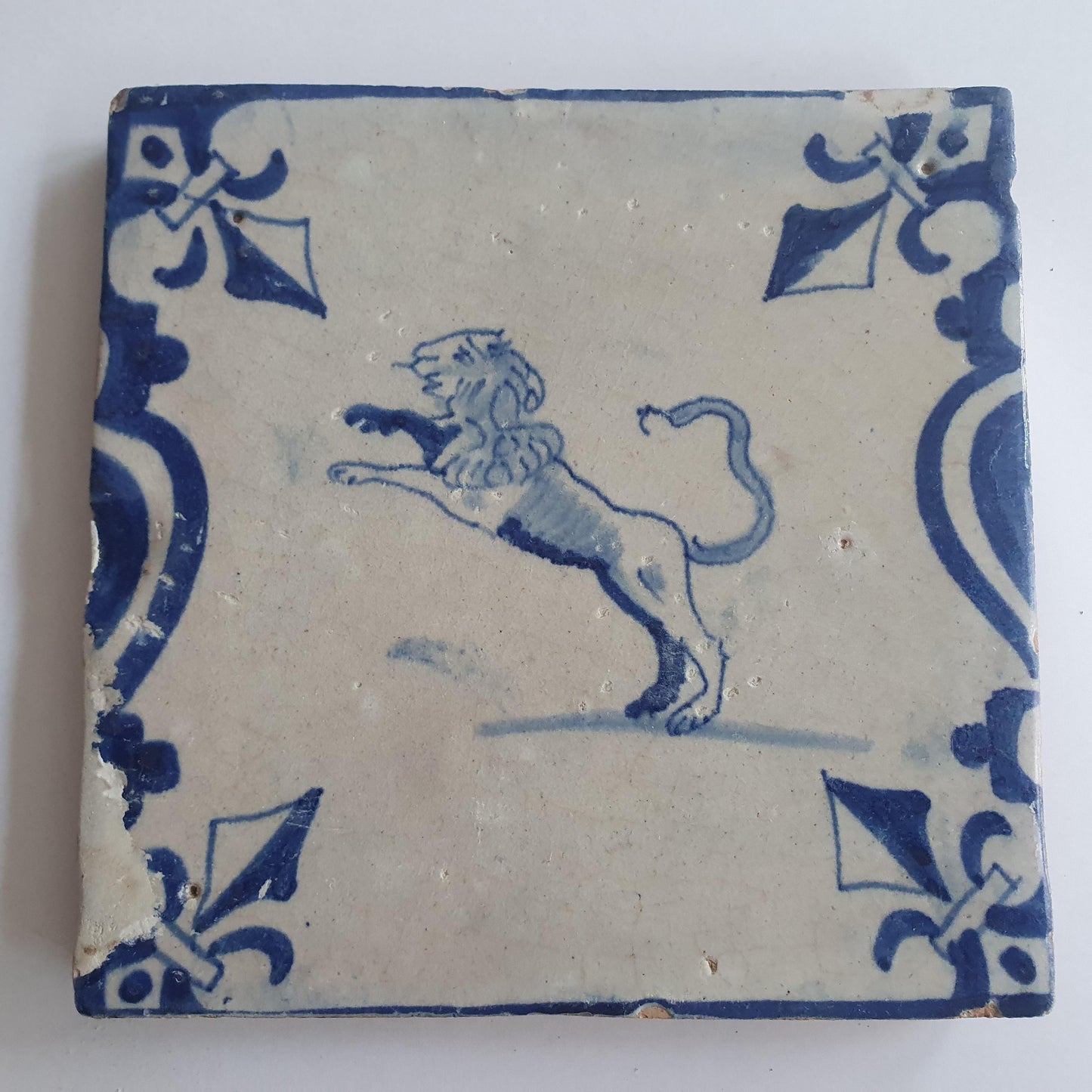 This 17th century Delft tile depicts a leaping lion, delicately painted in blue