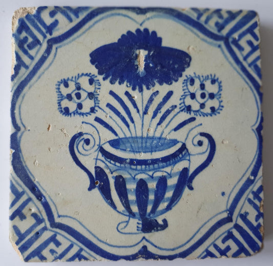 This antique Delft tile from the 17th century features a vase of flowers  1620- 1640
