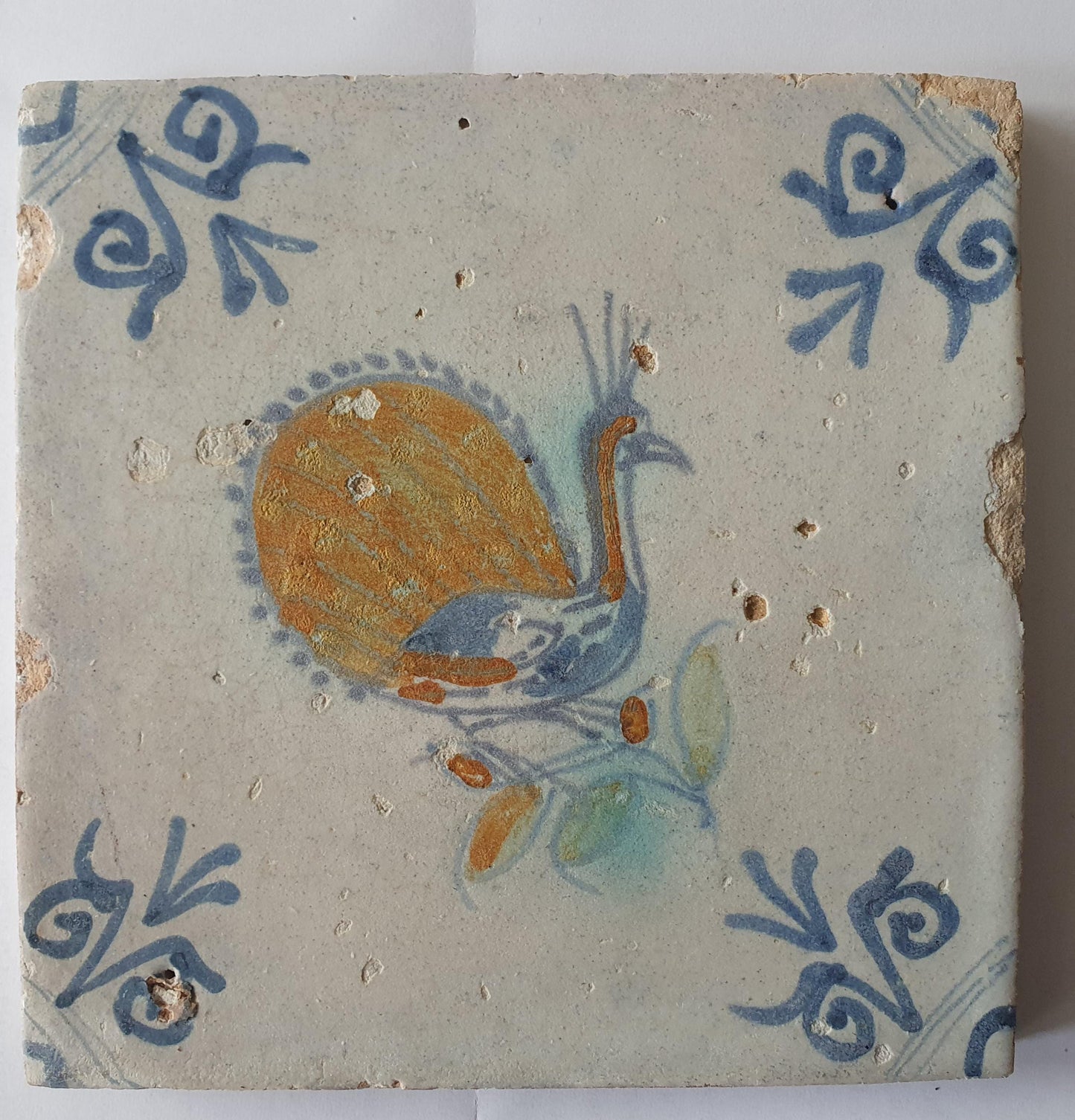 This 17th-century antique tile depicts a vividly hand-painted peacock