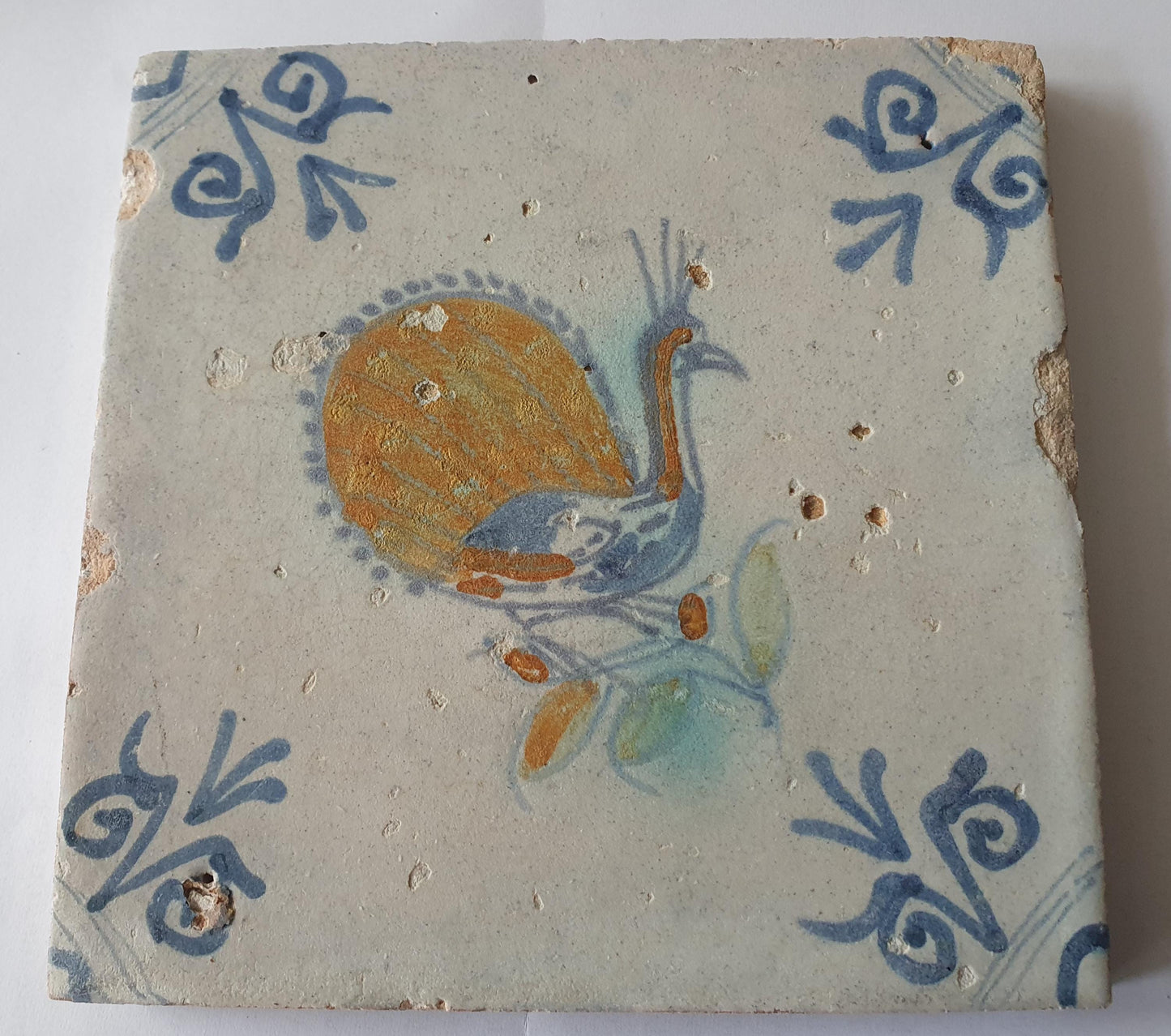 This 17th-century antique tile depicts a vividly hand-painted peacock