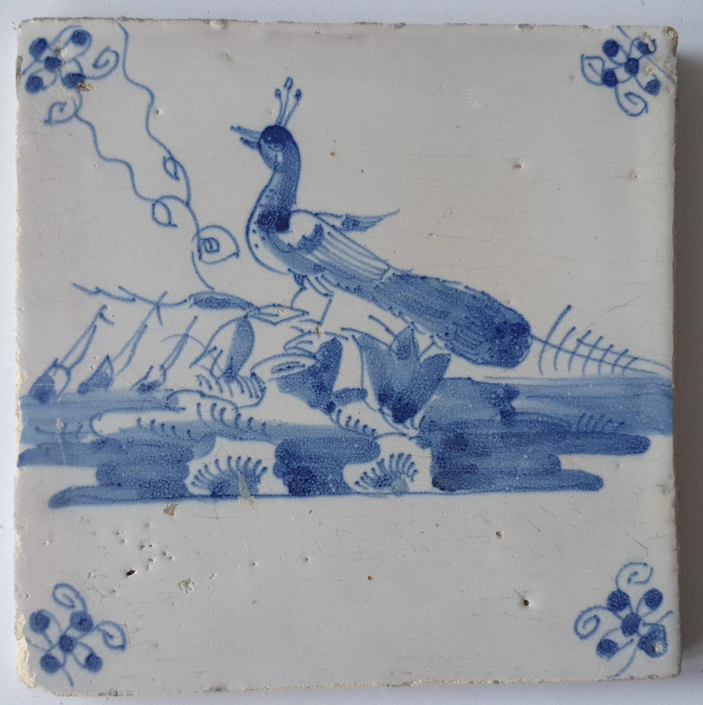 This  Delft tile depicts a peacock in blue.