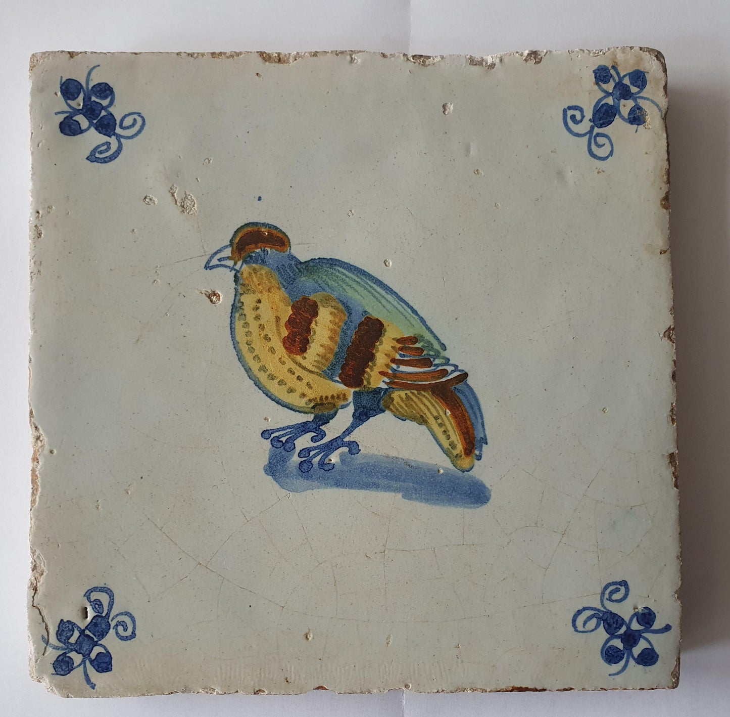 This antique Delft tile dates from around 1640 and depicts a beautifully hand-painted polychrome bird .