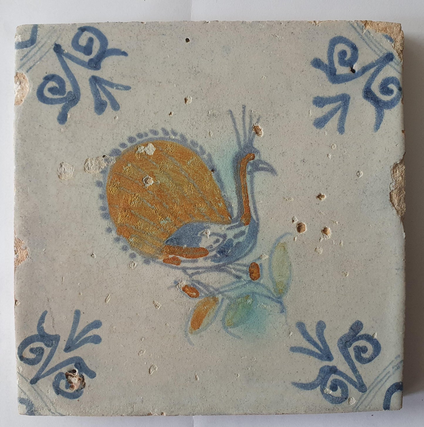 This 17th-century antique tile depicts a vividly hand-painted peacock