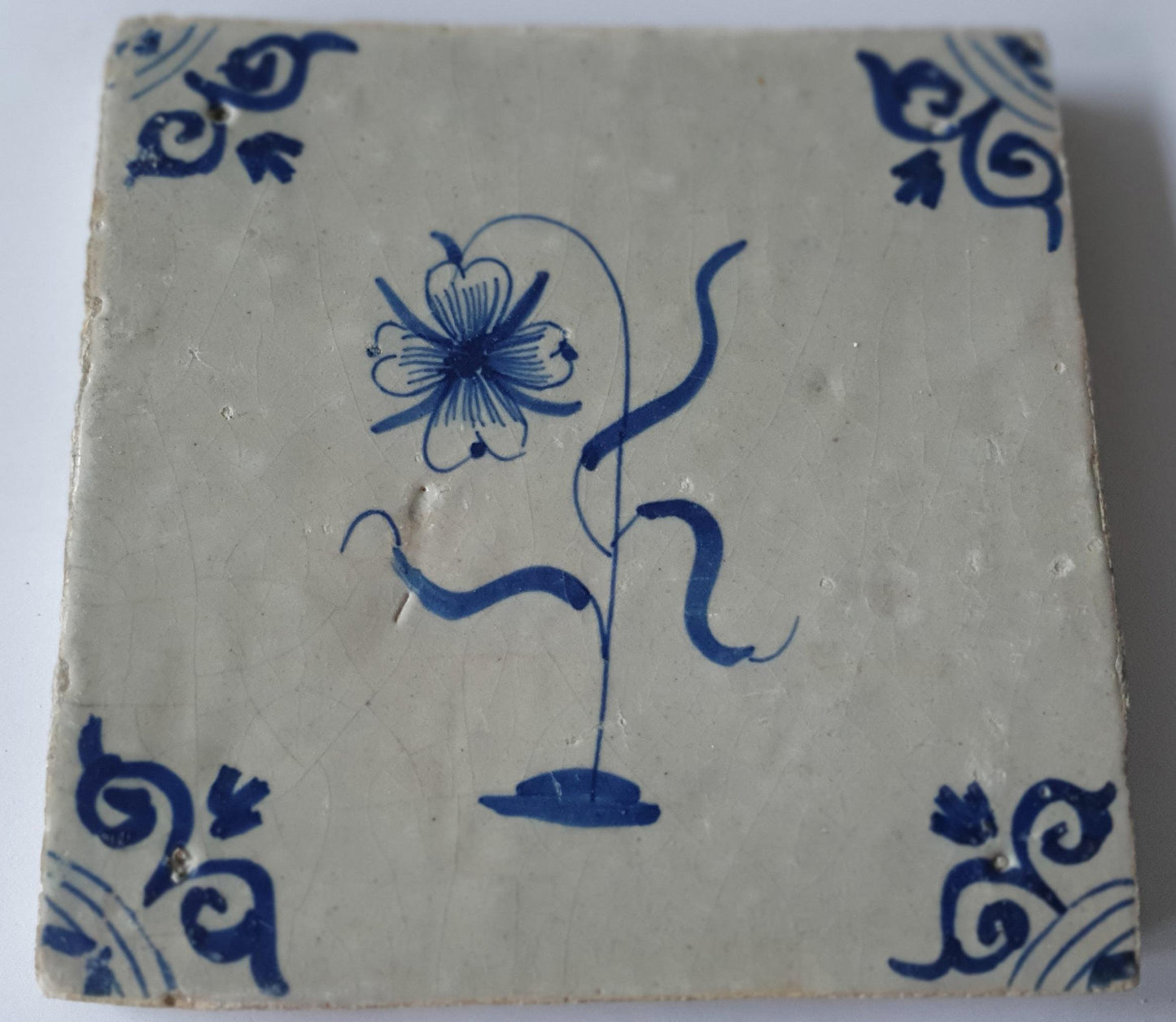 Deze  Delftse tegel toont een fraai geschilderde bloem en het blauw,  antieke Delft Blue Dutch 17e eeuw, verzameltegel.