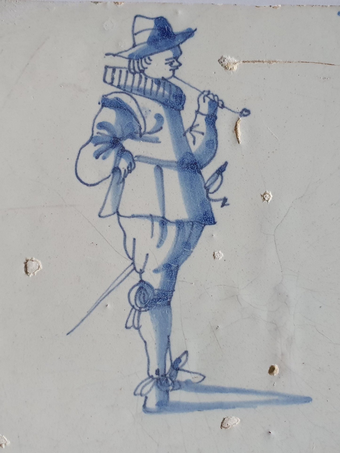 Delftse tegel dateert van rond 1640 en toont een heer die een lange tabakspijp rookt. ; 17e eeuw, verzameltegel, backsplash, fireplace
