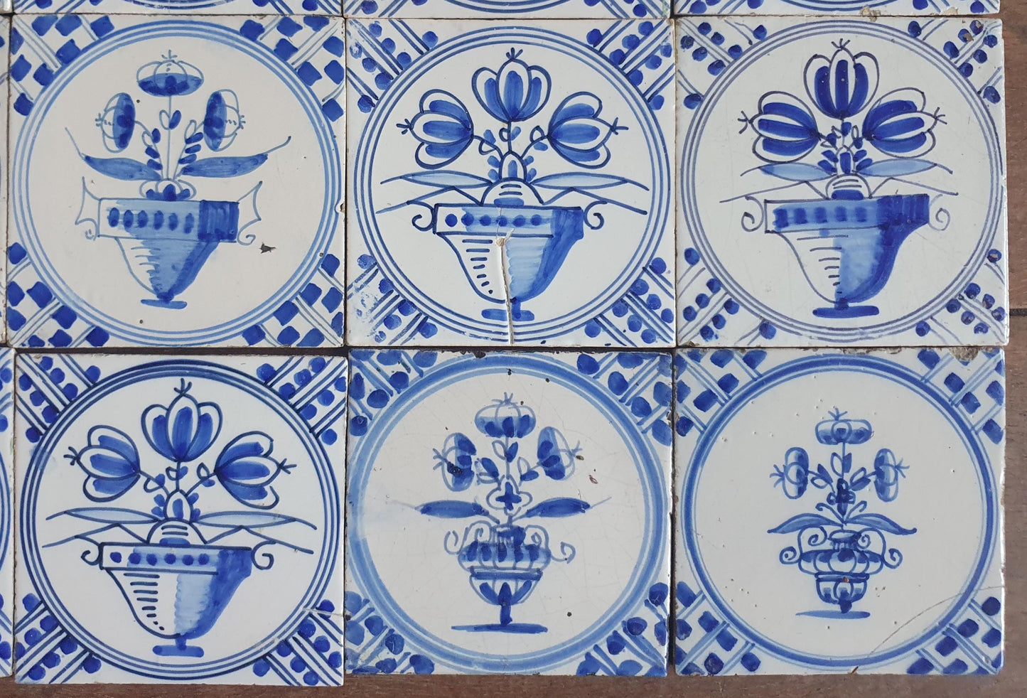 Set van 16 antieke Nederlandse wandtegels, cirkeltegels met bloemvazen in de kleur blauw; Delft Blue Dutch backsplash fireplace tiles.