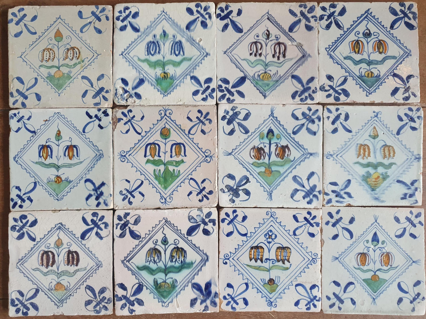 Set van 12 antieke Delftse ,Fritillaria-bloemen polychrome kwadraattegels, tilepanel 1e helft van de 17e eeuw. Delft Blue , verzameltegel, backsplash