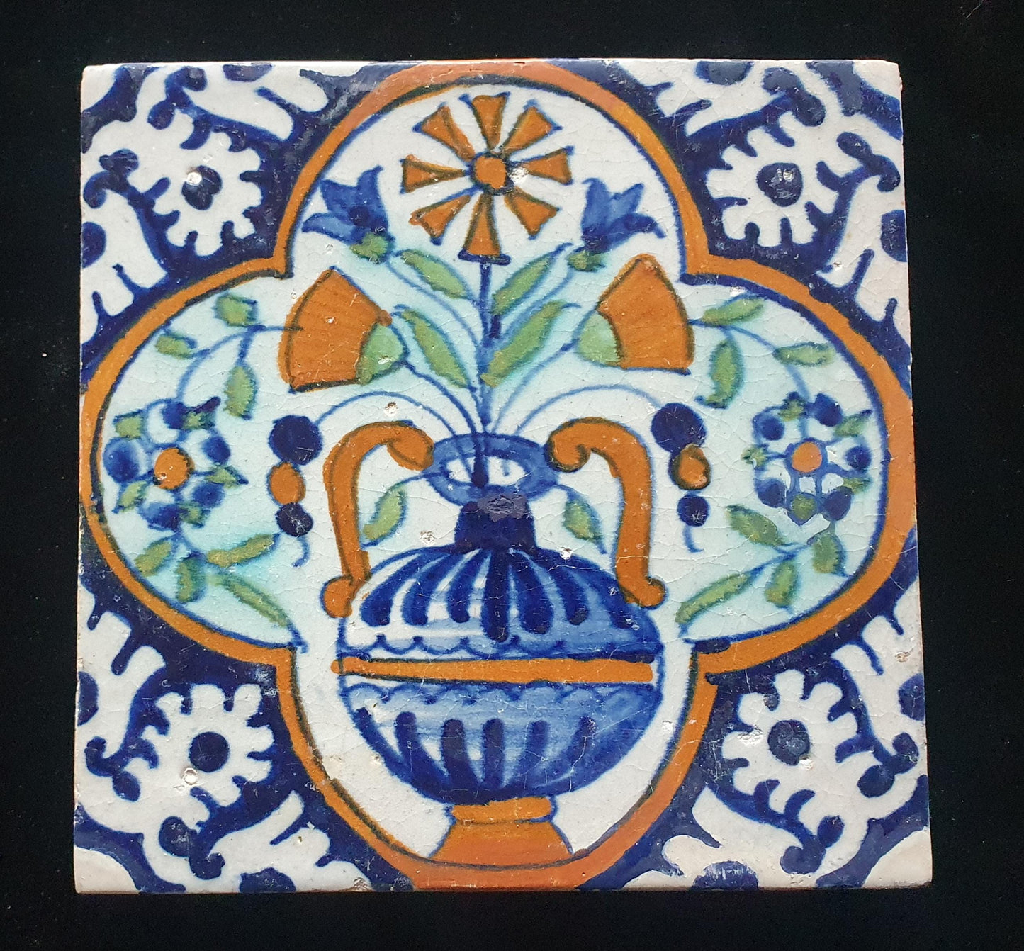 Een polychrome Nederlandse majolicategel met de decoratie van een kleurrijke bloemenvaas;  Dutch 17e eeuw, verzameltegel, backsplash