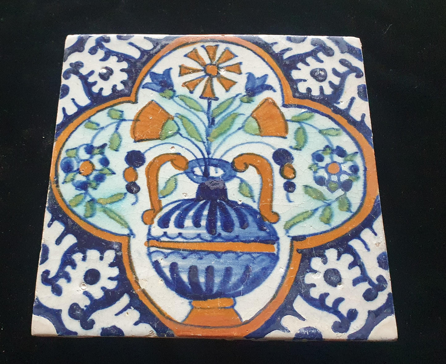 Een polychrome Nederlandse majolicategel met de decoratie van een kleurrijke bloemenvaas;  Dutch 17e eeuw, verzameltegel, backsplash