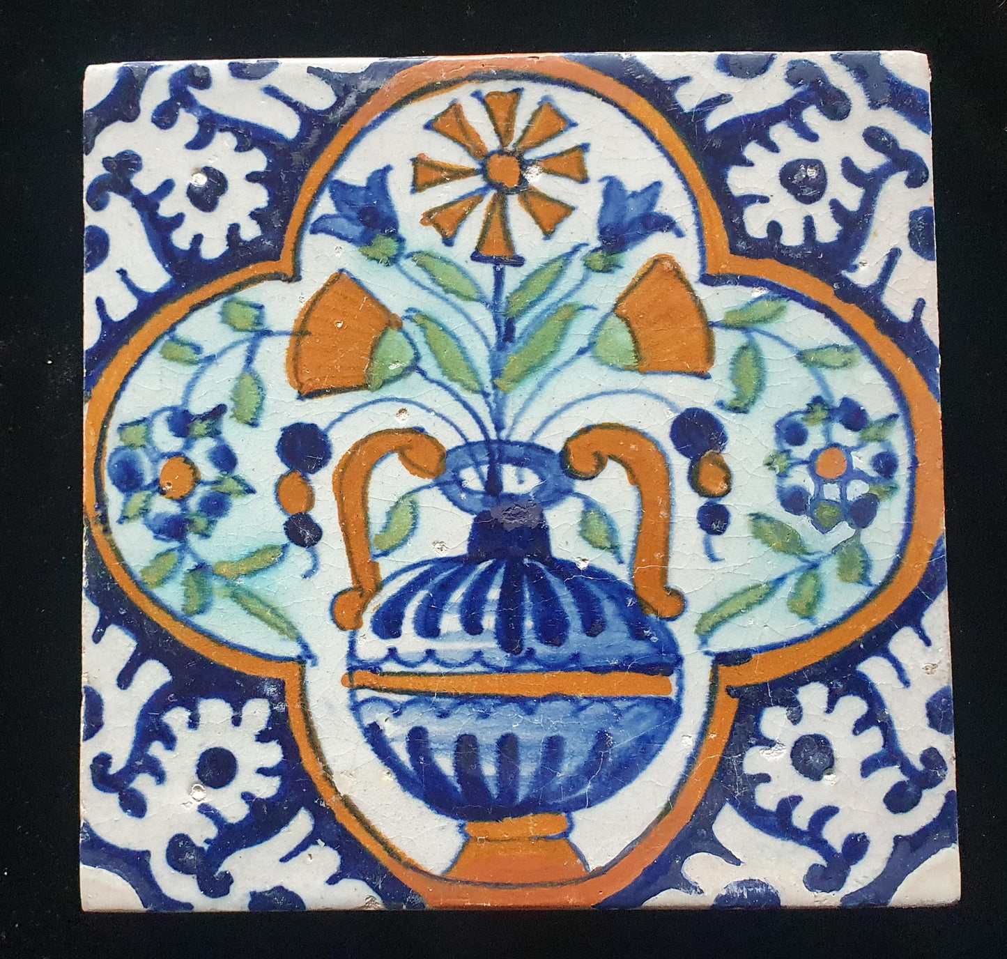 Een polychrome Nederlandse majolicategel met de decoratie van een kleurrijke bloemenvaas;  Dutch 17e eeuw, verzameltegel, backsplash
