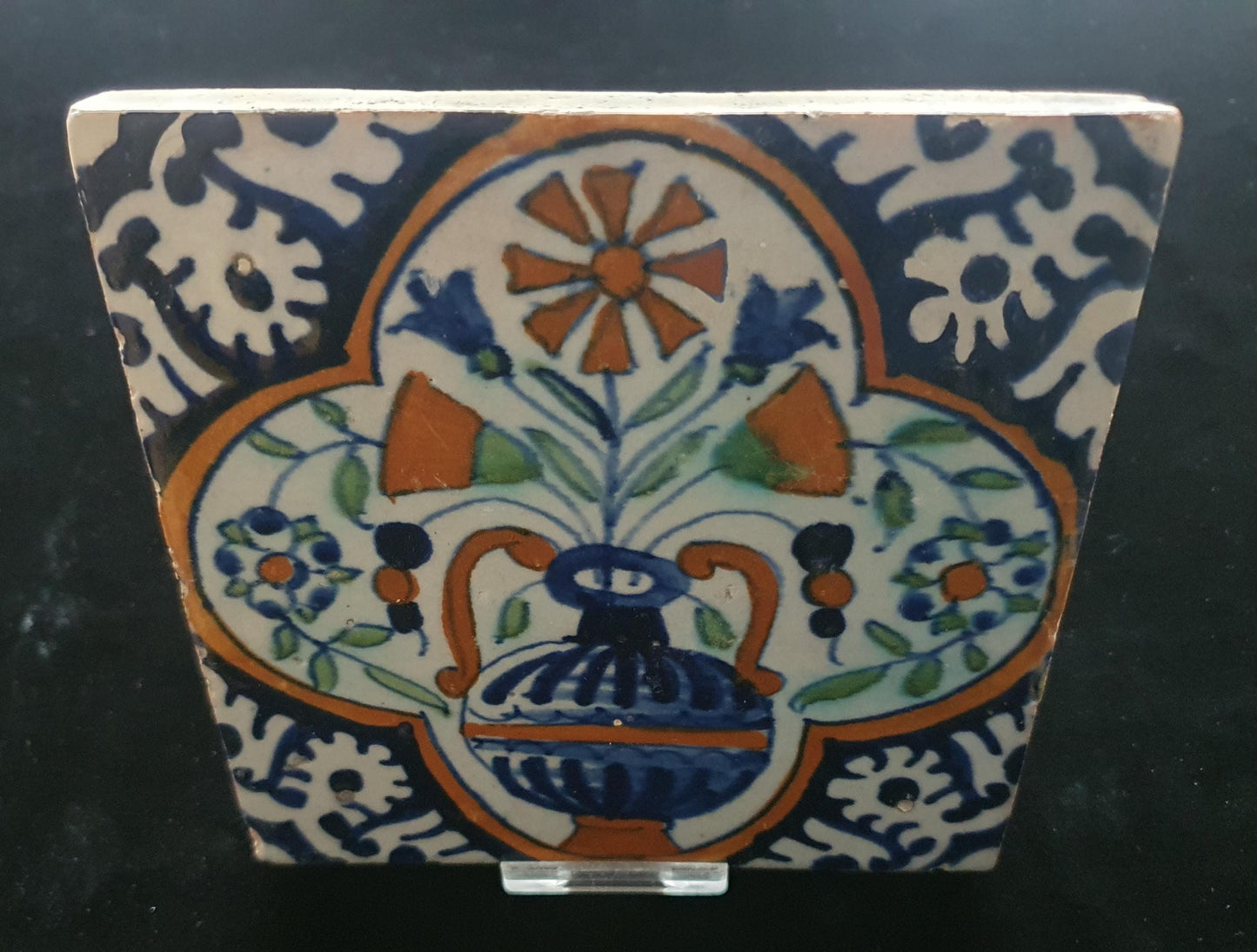 Een polychrome Nederlandse majolicategel met de decoratie van een kleurrijke bloemenvaas;  Dutch 17e eeuw, verzameltegel, backsplash