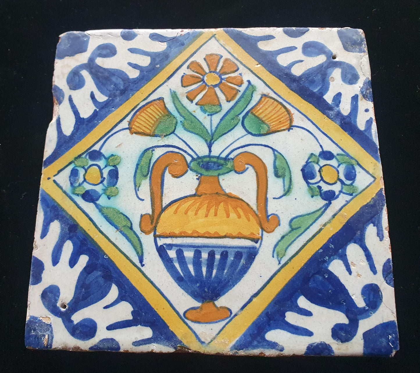 Een polychrome Nederlandse majolicategel met de decoratie van een kleurrijke bloemenvaas;  Dutch 17e eeuw, verzameltegel, backsplash