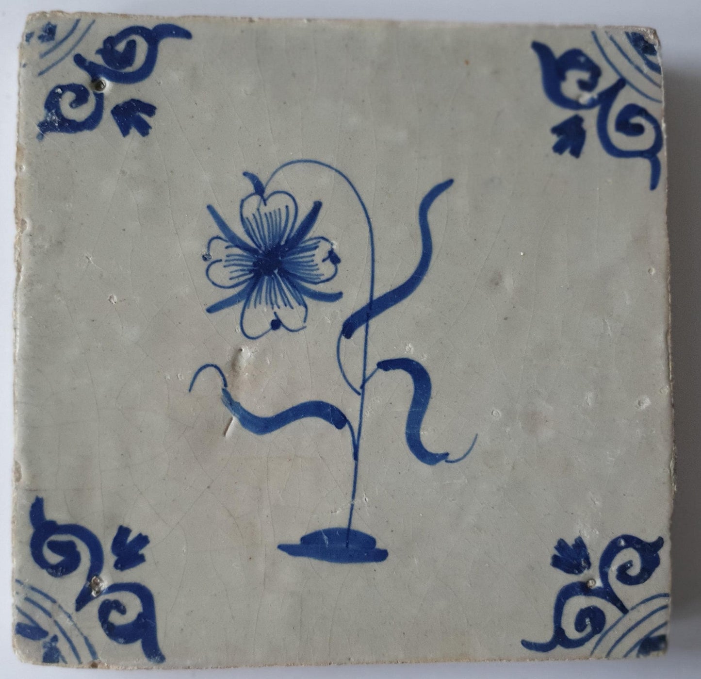 Deze  Delftse tegel toont een fraai geschilderde bloem en het blauw,  antieke Delft Blue Dutch 17e eeuw, verzameltegel.