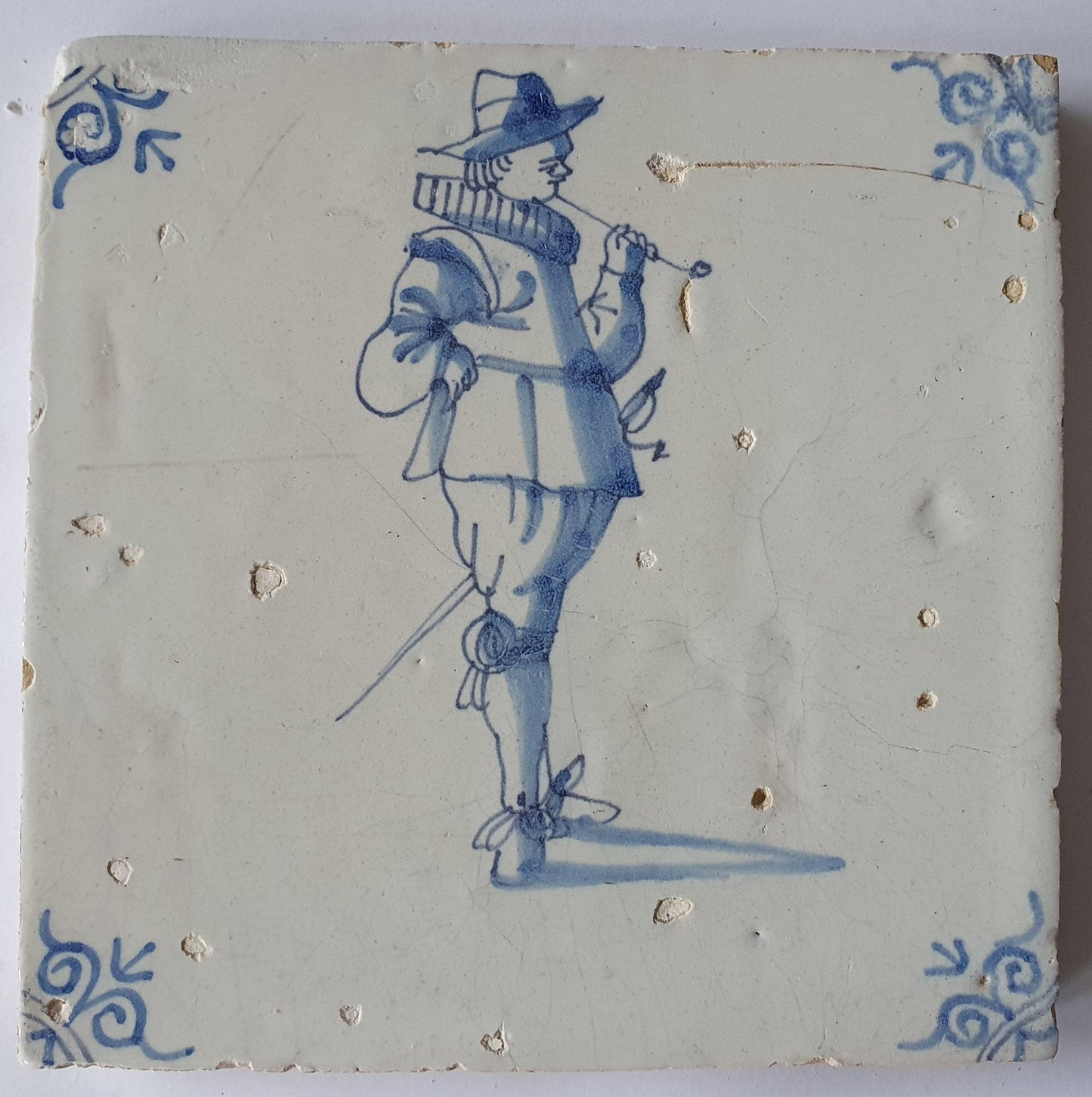 Delftse tegel dateert van rond 1640 en toont een heer die een lange tabakspijp rookt. ; 17e eeuw, verzameltegel, backsplash, fireplace