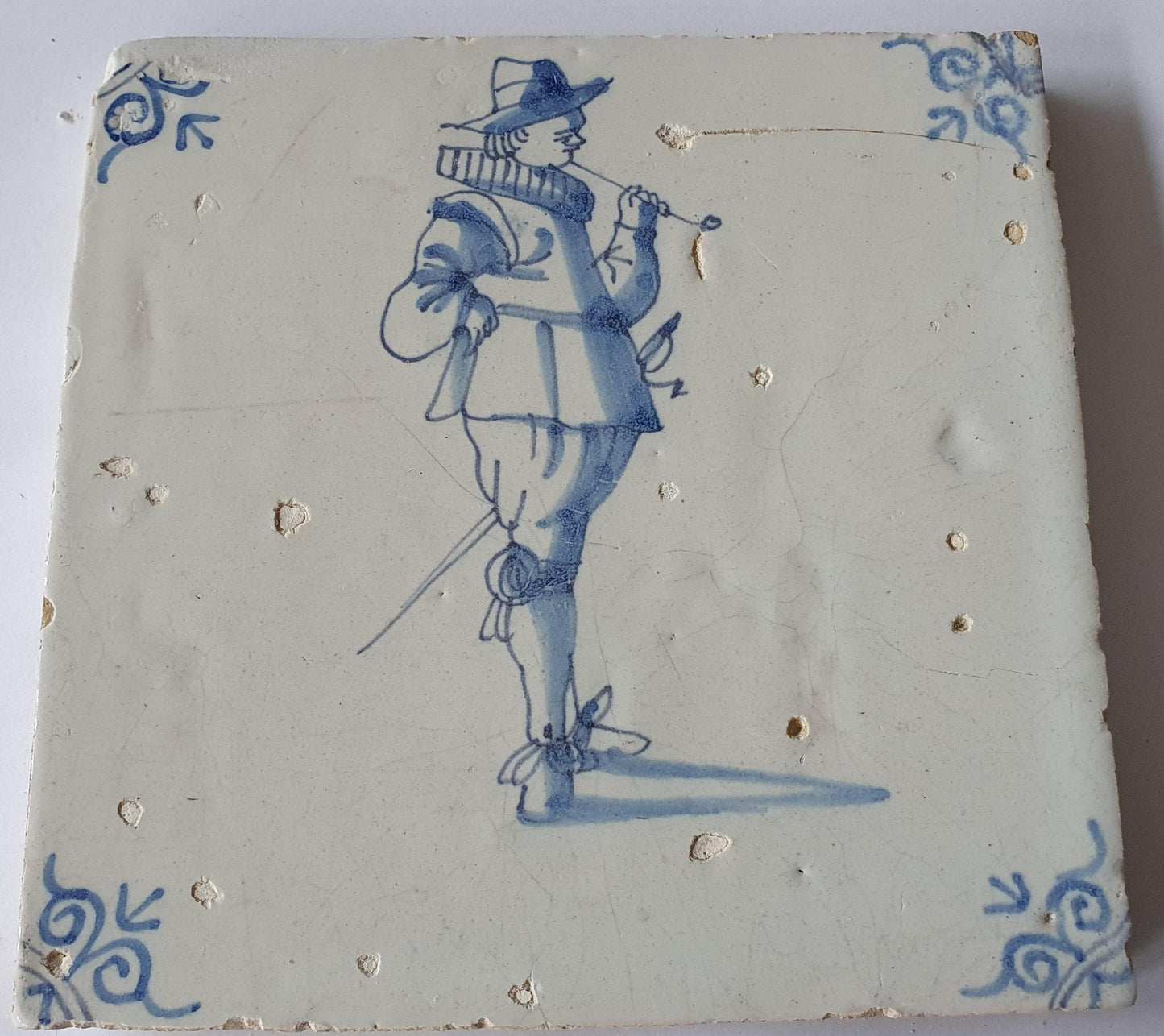 Delftse tegel dateert van rond 1640 en toont een heer die een lange tabakspijp rookt. ; 17e eeuw, verzameltegel, backsplash, fireplace