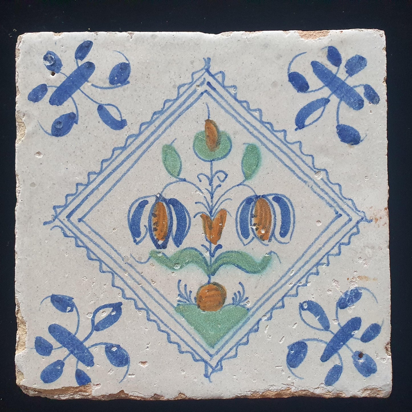 Een polychrome Hollandse tegel deze is gemaakt rond 1650 en toont een Fritillaria (Slangenkopbloem);  Dutch 17e eeuw, verzameltegel.