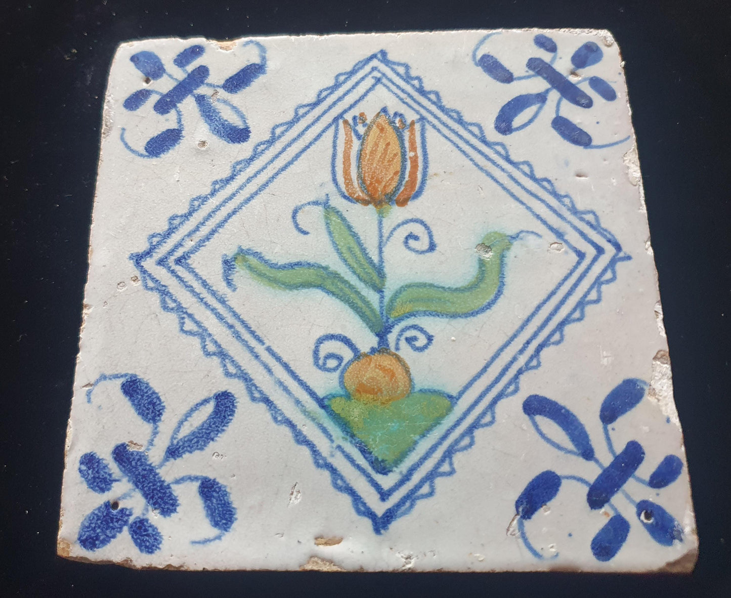 Een polychrome Hollandse tegel deze is gemaakt rond 1650 en toont een tulp in vierkant;  Dutch 17e eeuw, verzameltegel.