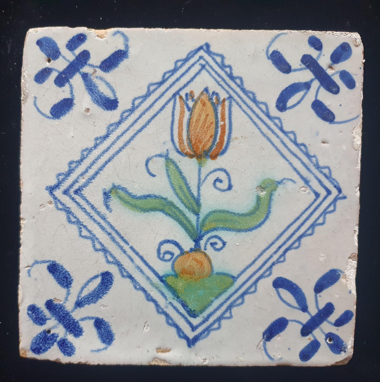 Een polychrome Hollandse tegel deze is gemaakt rond 1650 en toont een tulp in vierkant;  Dutch 17e eeuw, verzameltegel.